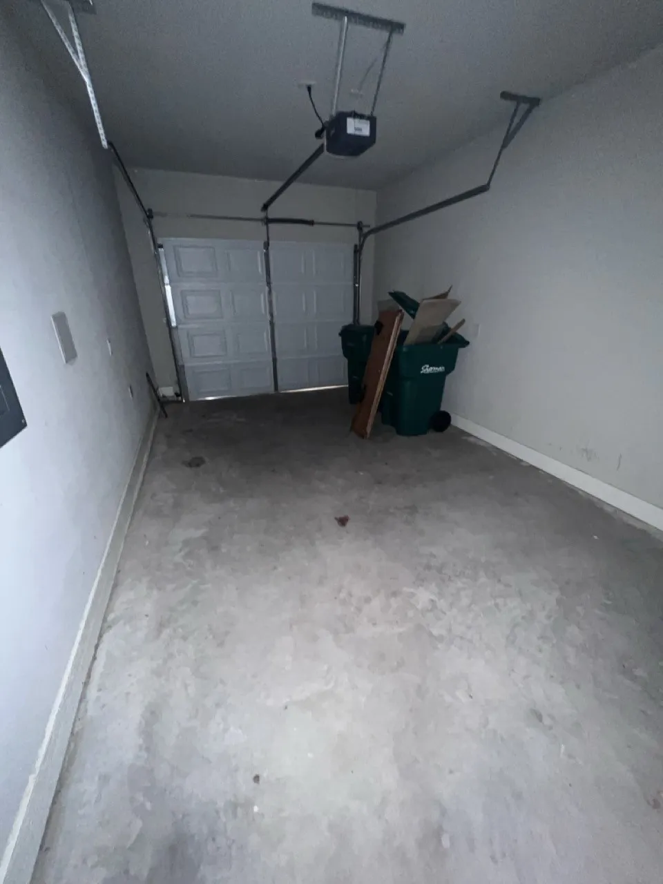Garage featuring a concrete floor, white walls, and a sectional overhead garage door