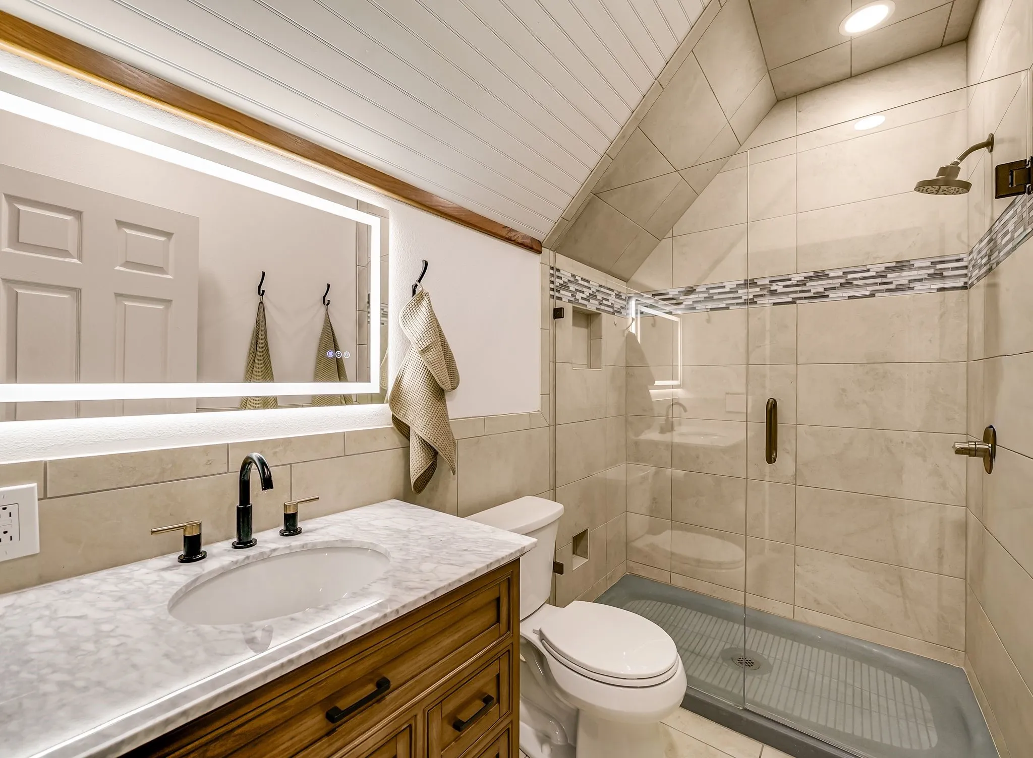 Full Bathroom #4 off Studio Contemporary bathroom featuring a wood-finish vanity with a stone countertop and an oval undermount sink