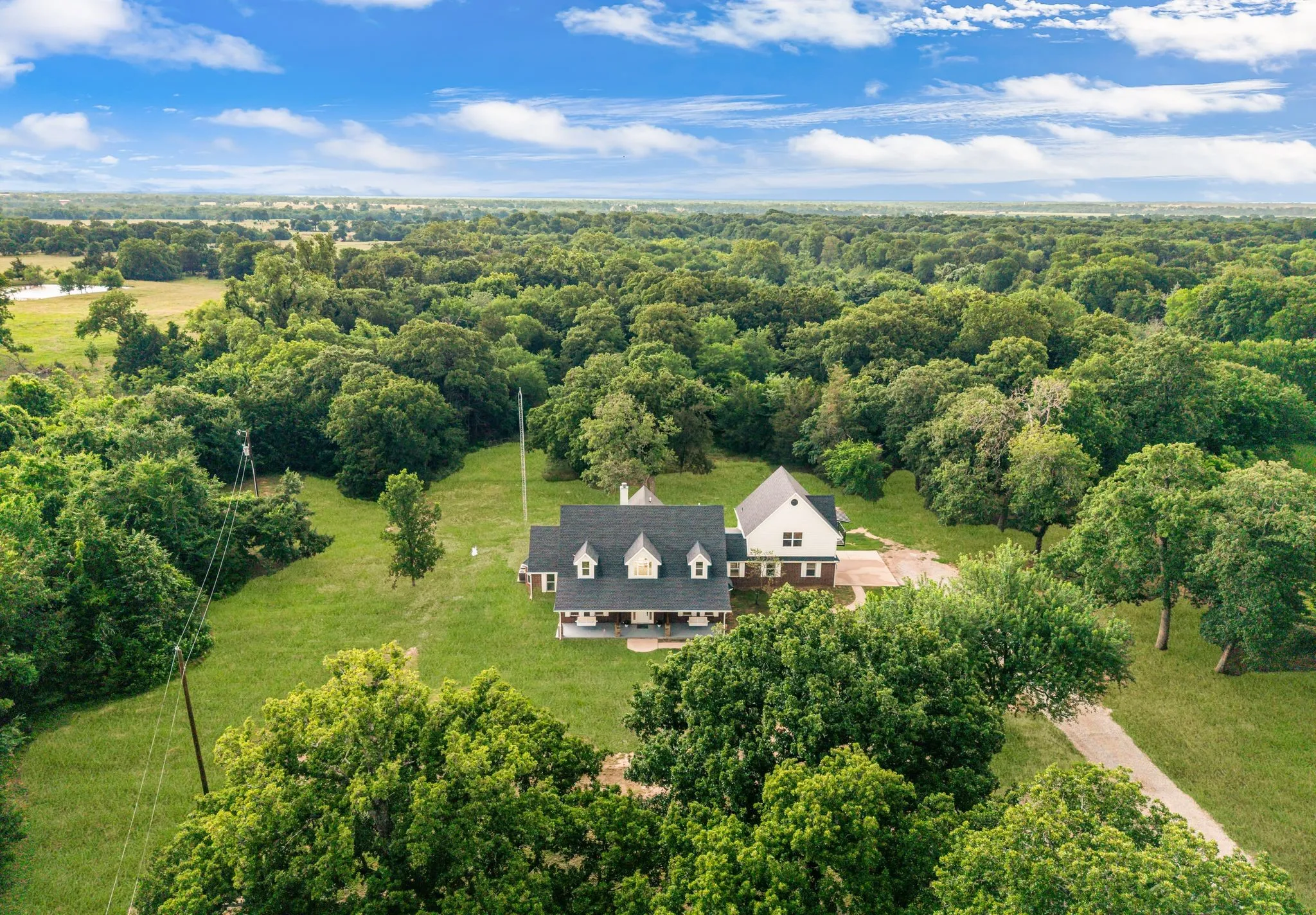 Expansive property featuring a multi-gable roofline, dormer windows, and a brick and siding exterior