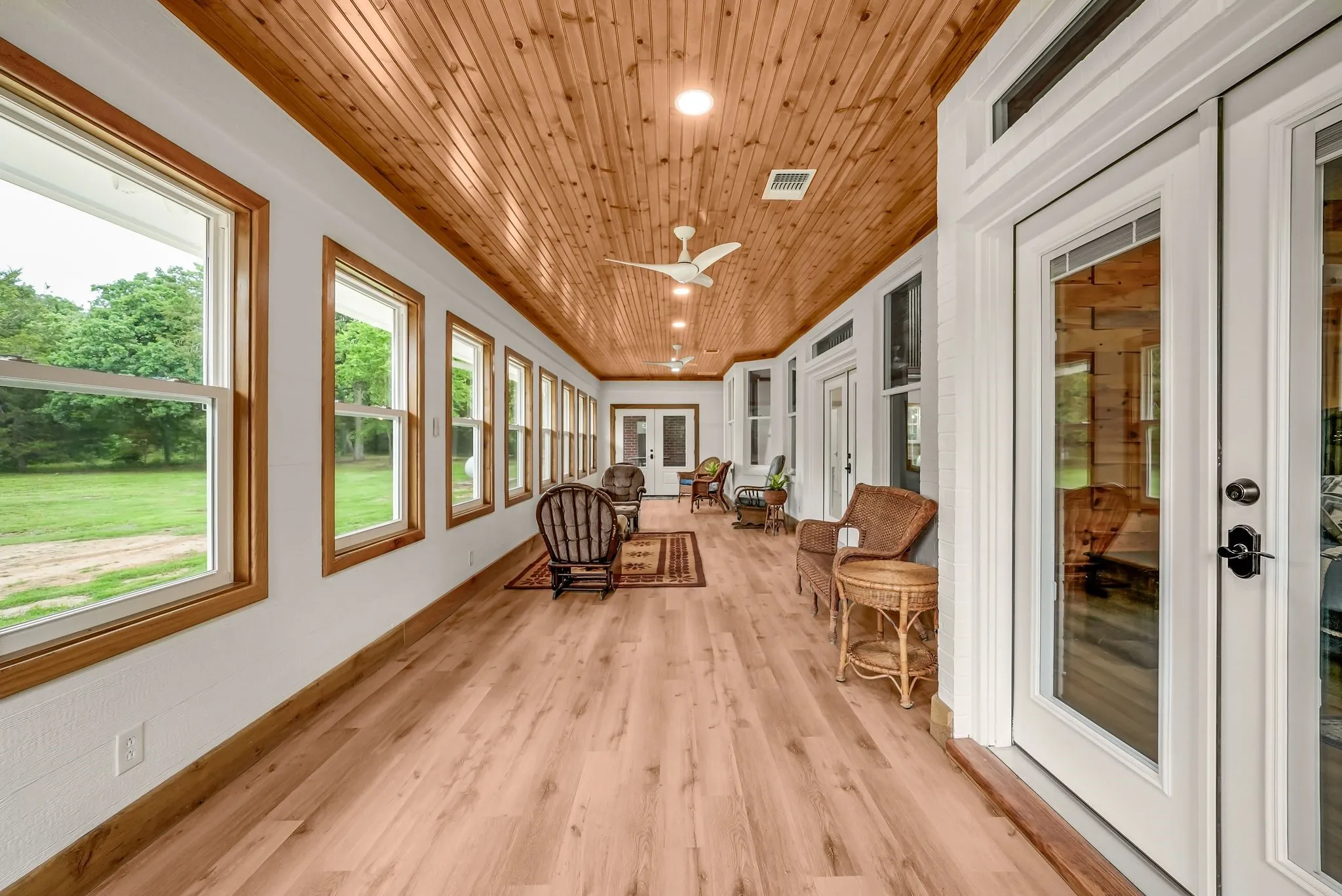 Spacious sunroom featuring extensive wood-finish flooring and a natural wood plank ceiling