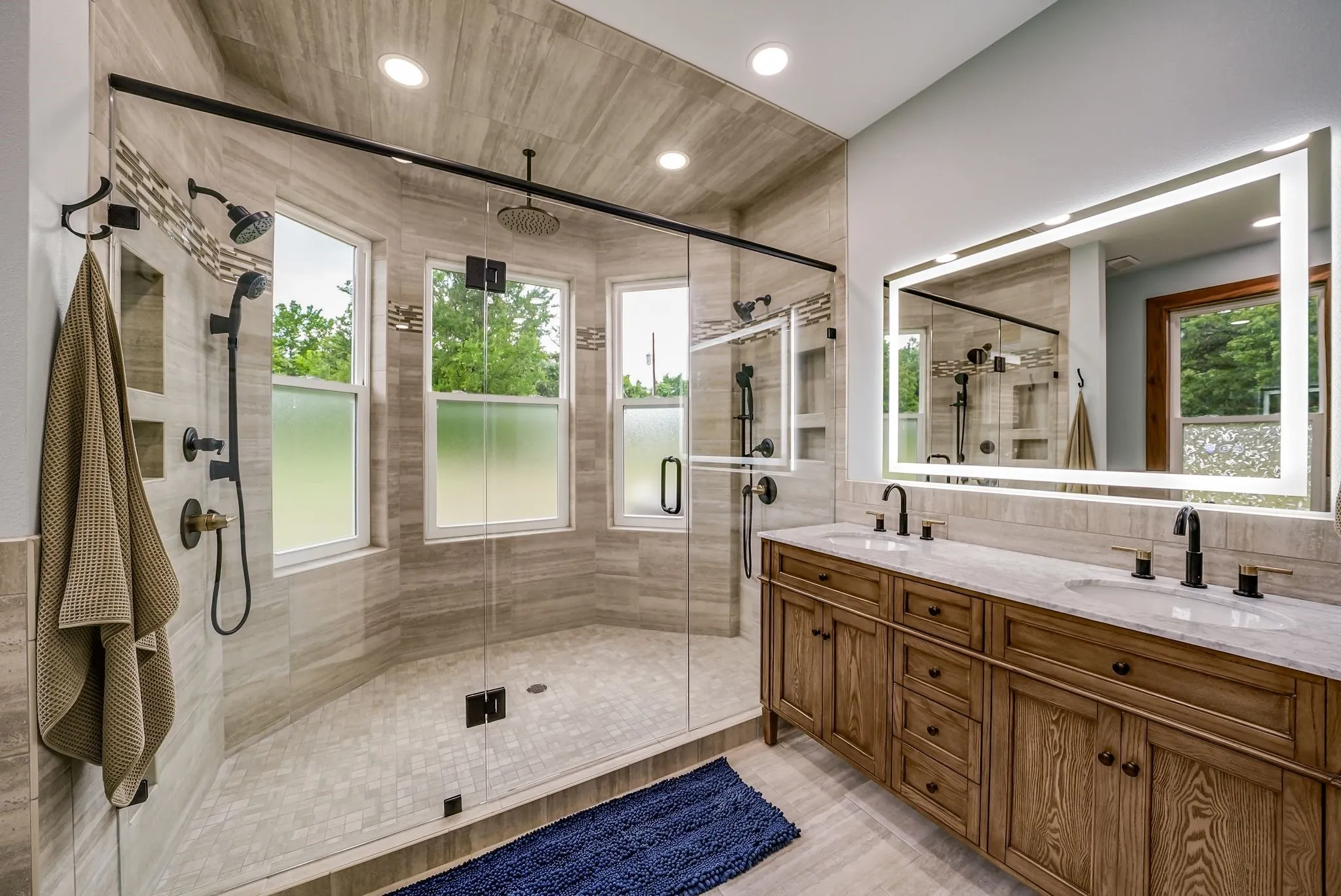 Main Spacious bathroom featuring a dual-sink vanity with wood cabinetry and stone countertops