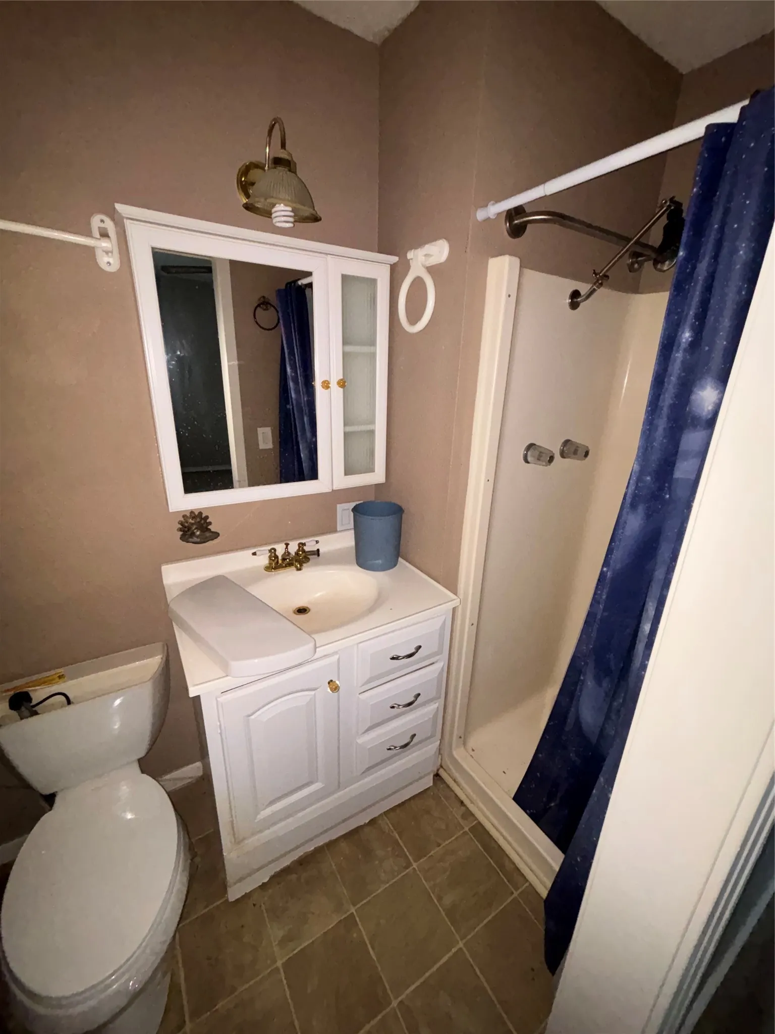 Bathroom featuring a white vanity with integrated sink, coordinating wall-mounted medicine cabinet, and a stand-up shower enclosure
