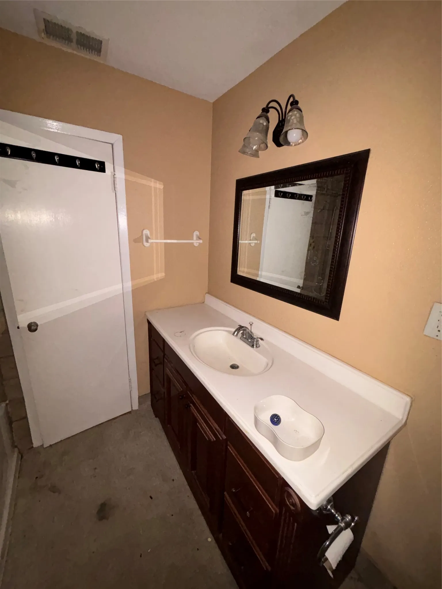 Bathroom vanity with a single basin sink and a dark wood-finish cabinet