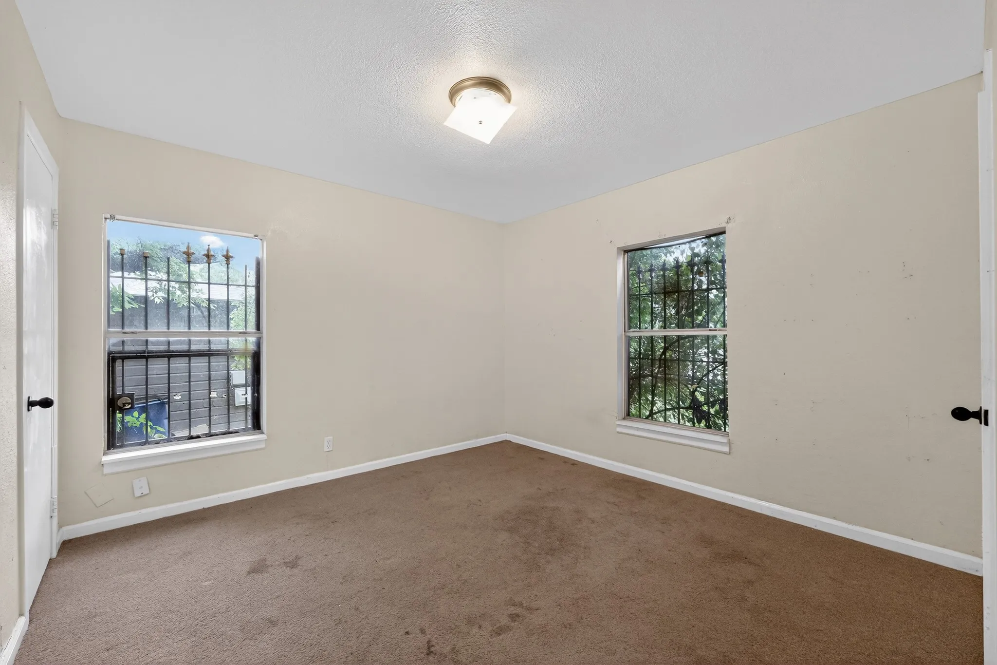 Neutral-toned walls complement the brown carpet flooring and white trim