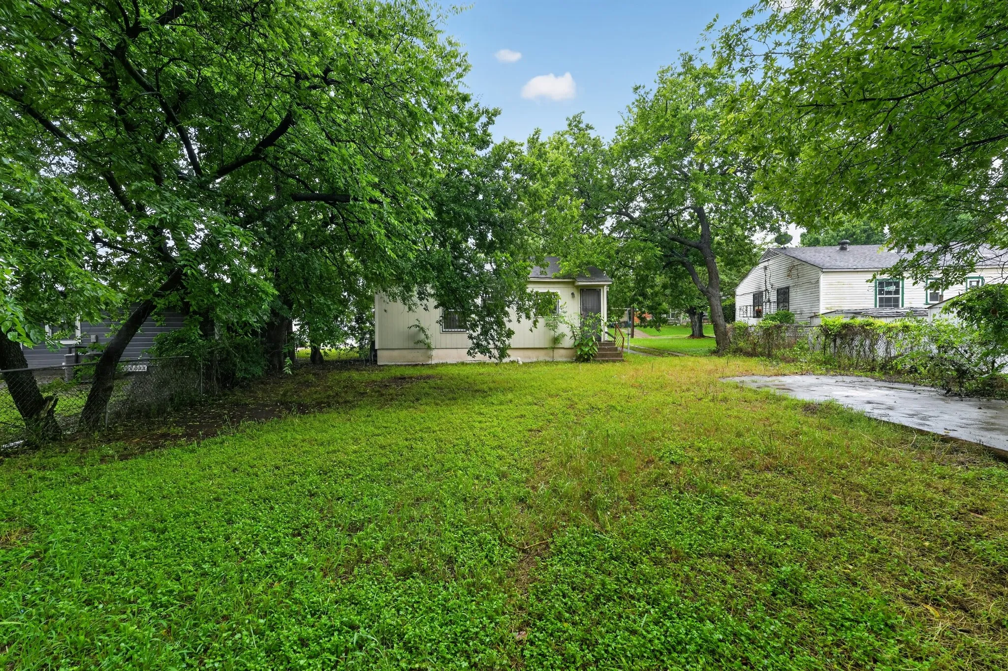 Expansive yard featuring mature trees and a detached structure