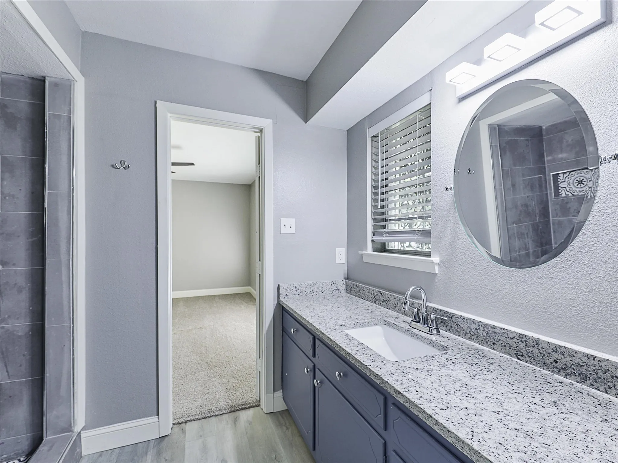 Beautifully updated secondary bath with granite countertops, designer tile surround, and modern finishes.