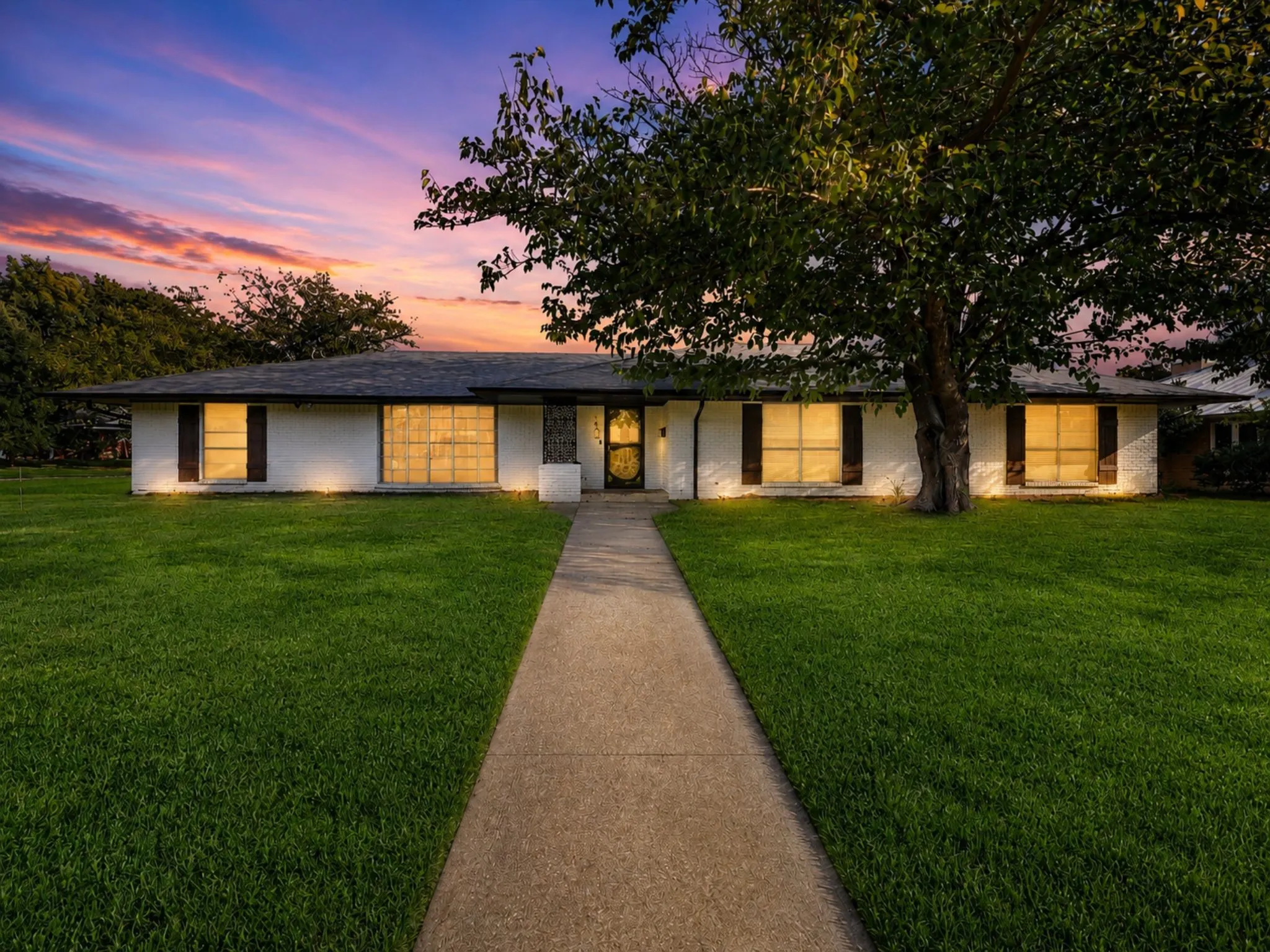 Beautifully updated home nestled beneath mature shade trees with exceptional curb appeal and a welcoming presence day or night.