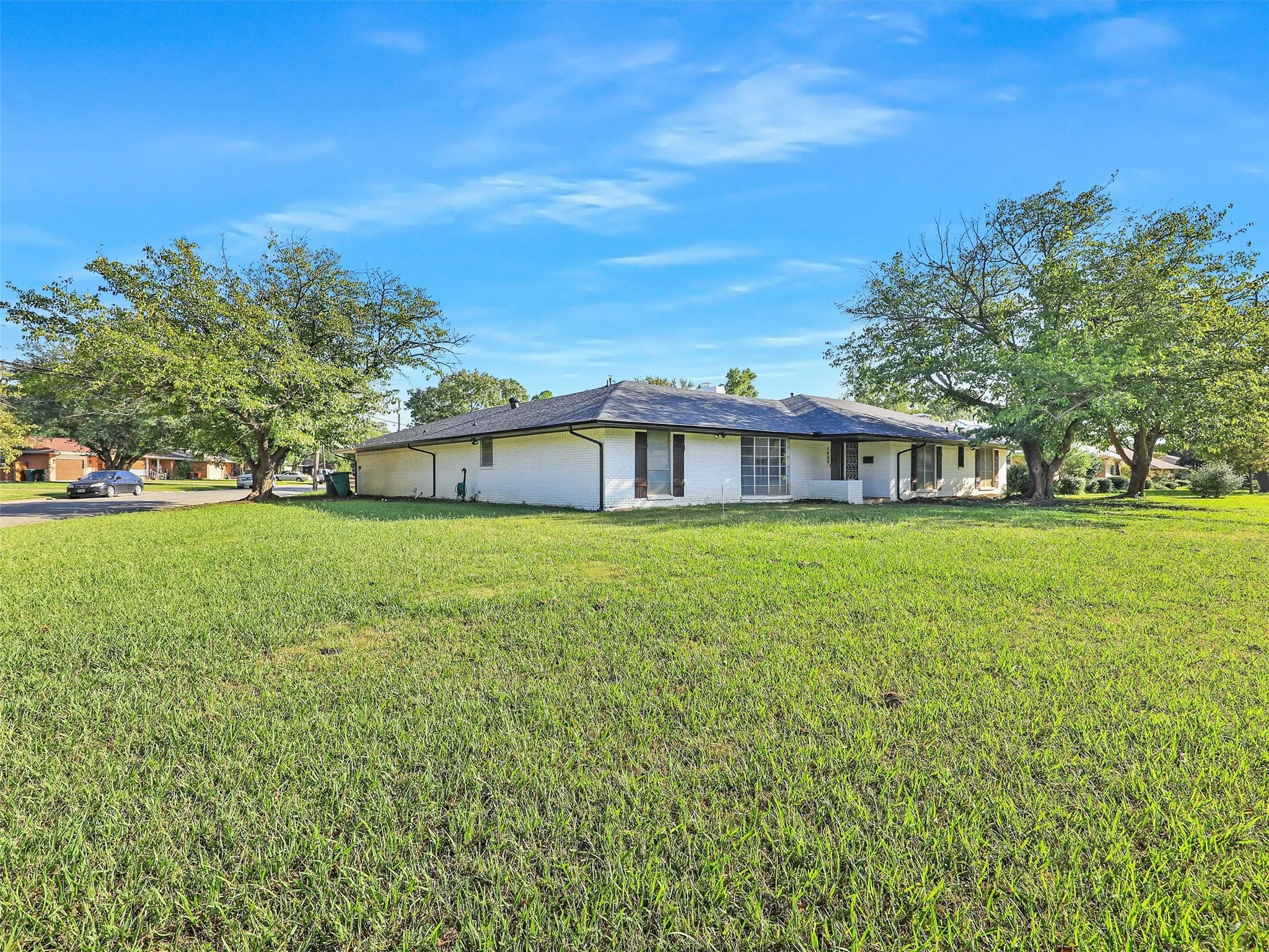 Situated on a spacious corner lot with mature shade trees, offering exceptional curb appeal and room to spread out.