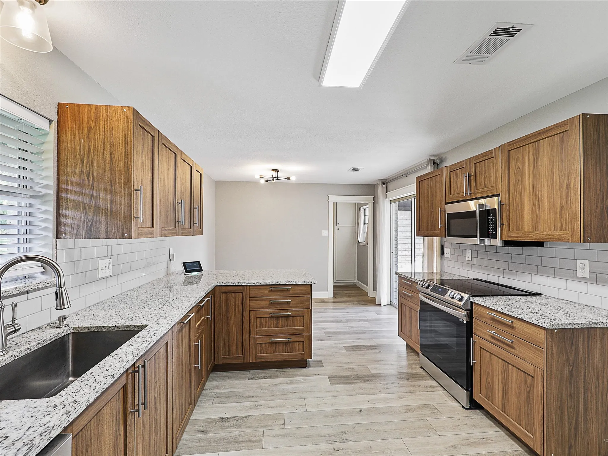 Beautifully updated kitchen featuring abundant cabinetry, expansive countertops, and a layout designed for everyday living and effortless entertaining.
