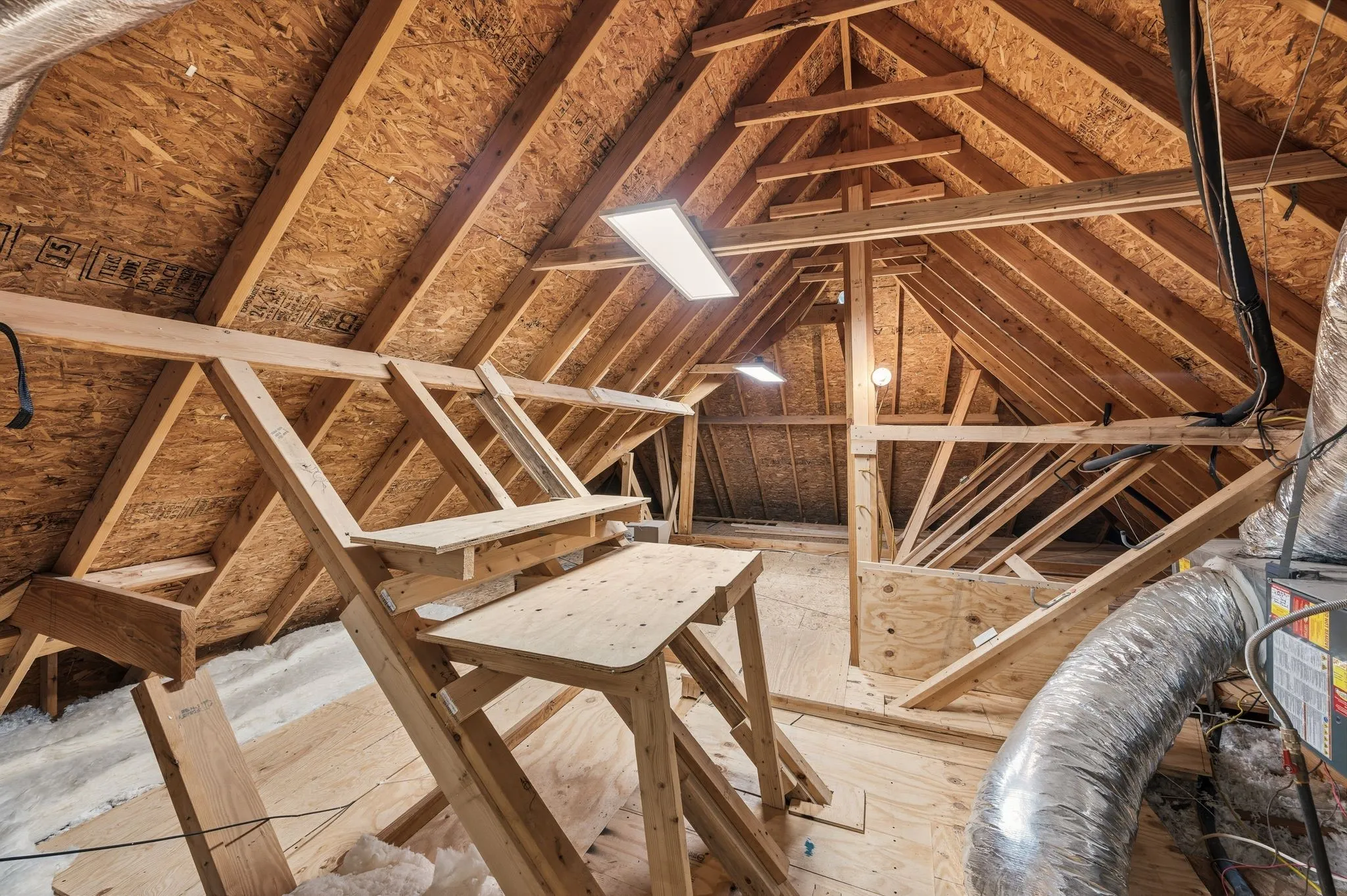 Attic has plenty of floored storage space, a work bench and task lighting