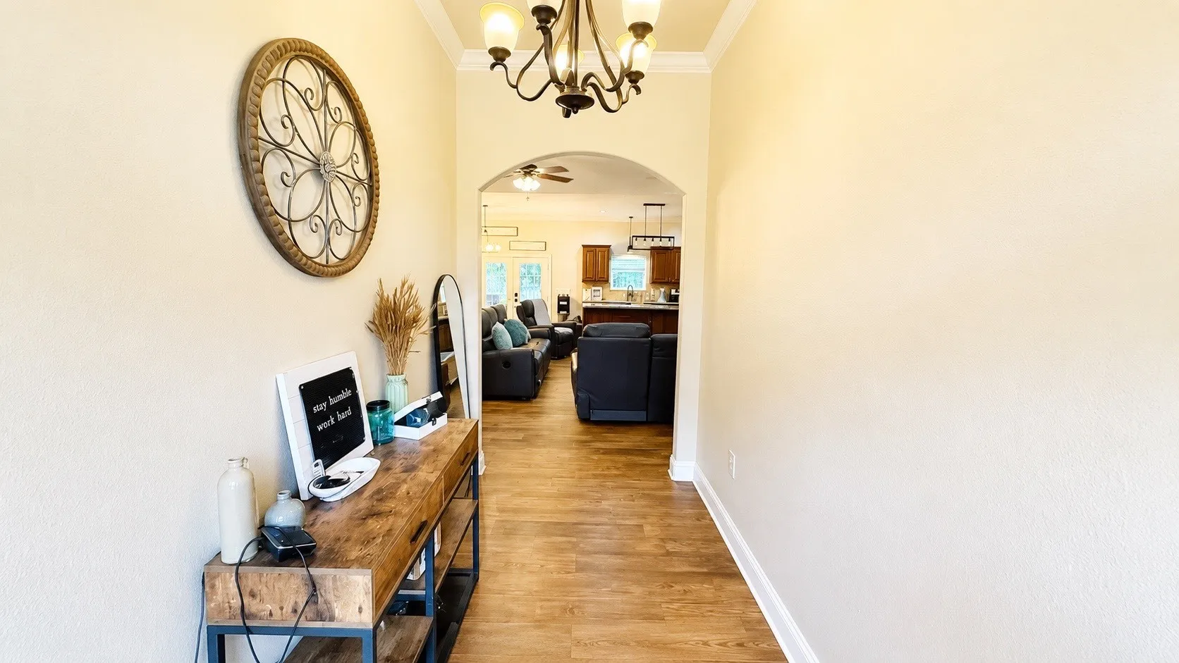 Arched doorway opening to an expansive interior with wood-finish flooring