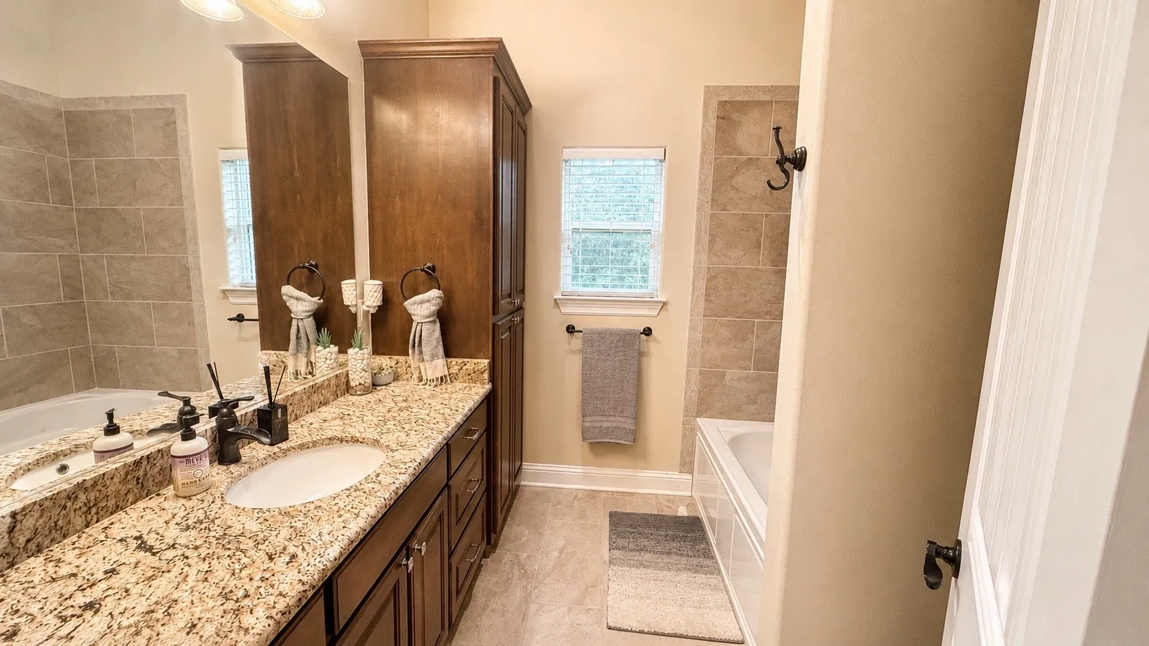 Double vanity with stone countertop and dark wood cabinetry