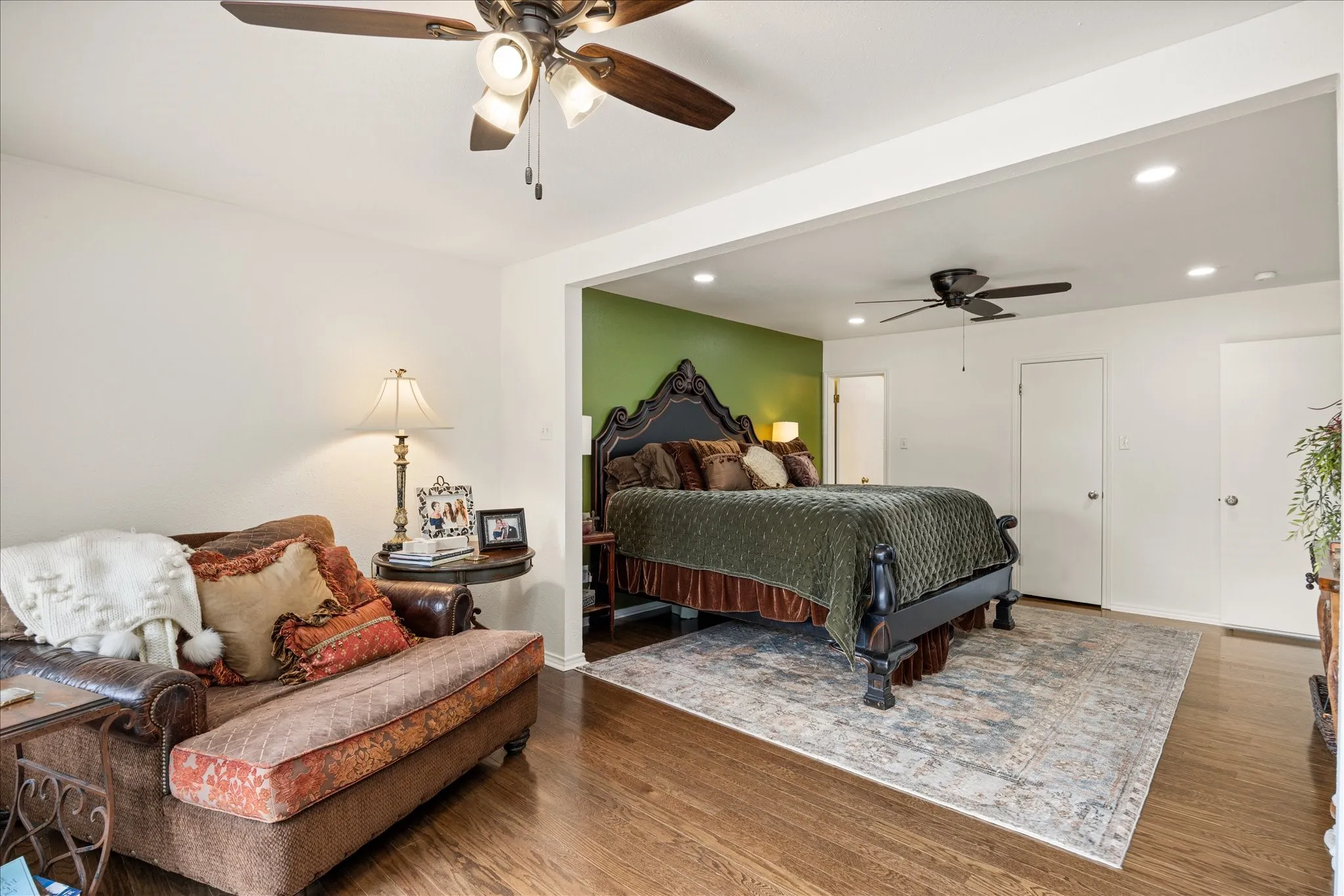 Bedroom featuring an accent wall, recessed lighting, wood-finish flooring, and two ceiling fans