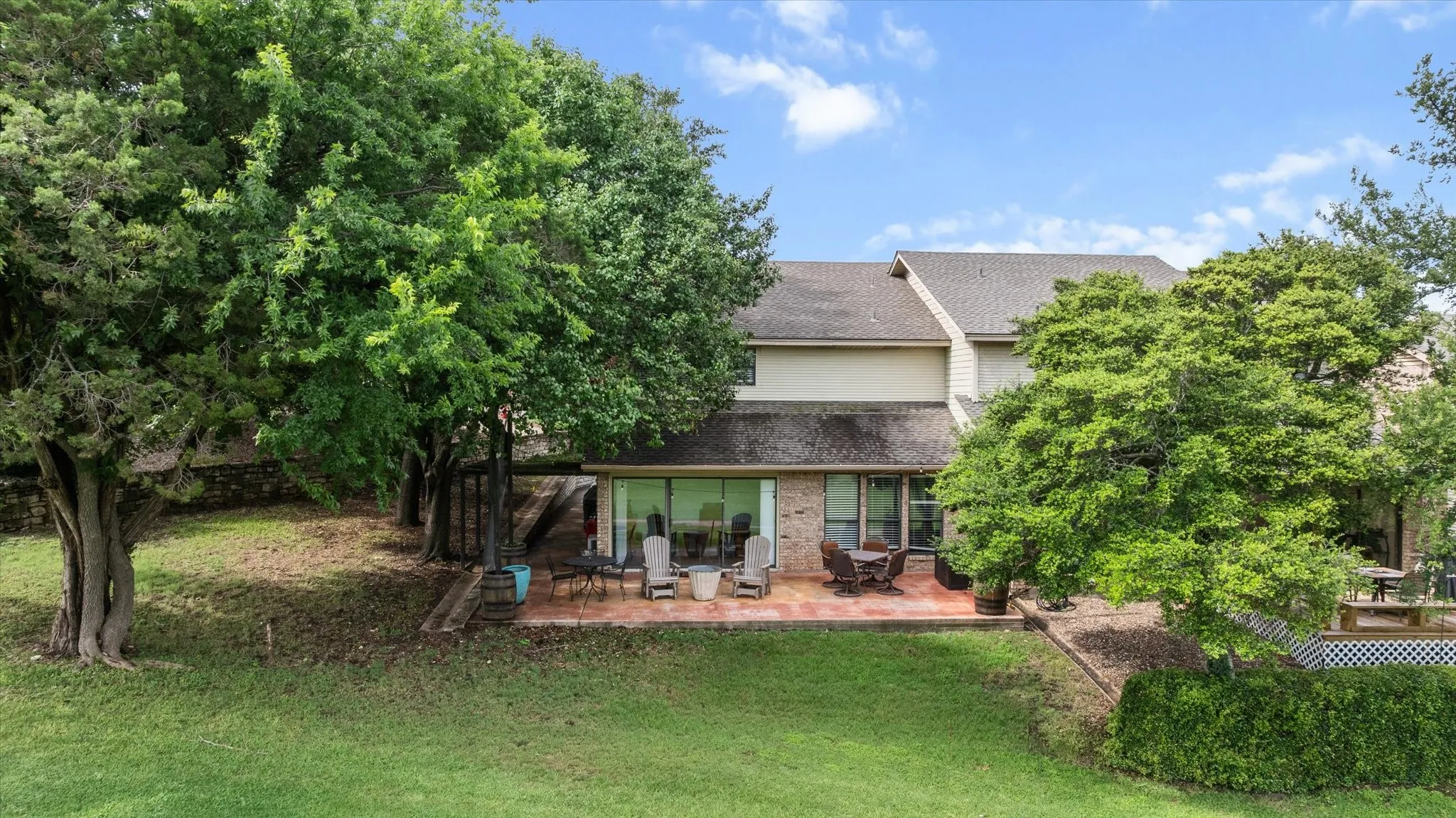 Backyard featuring a large patio, mature trees