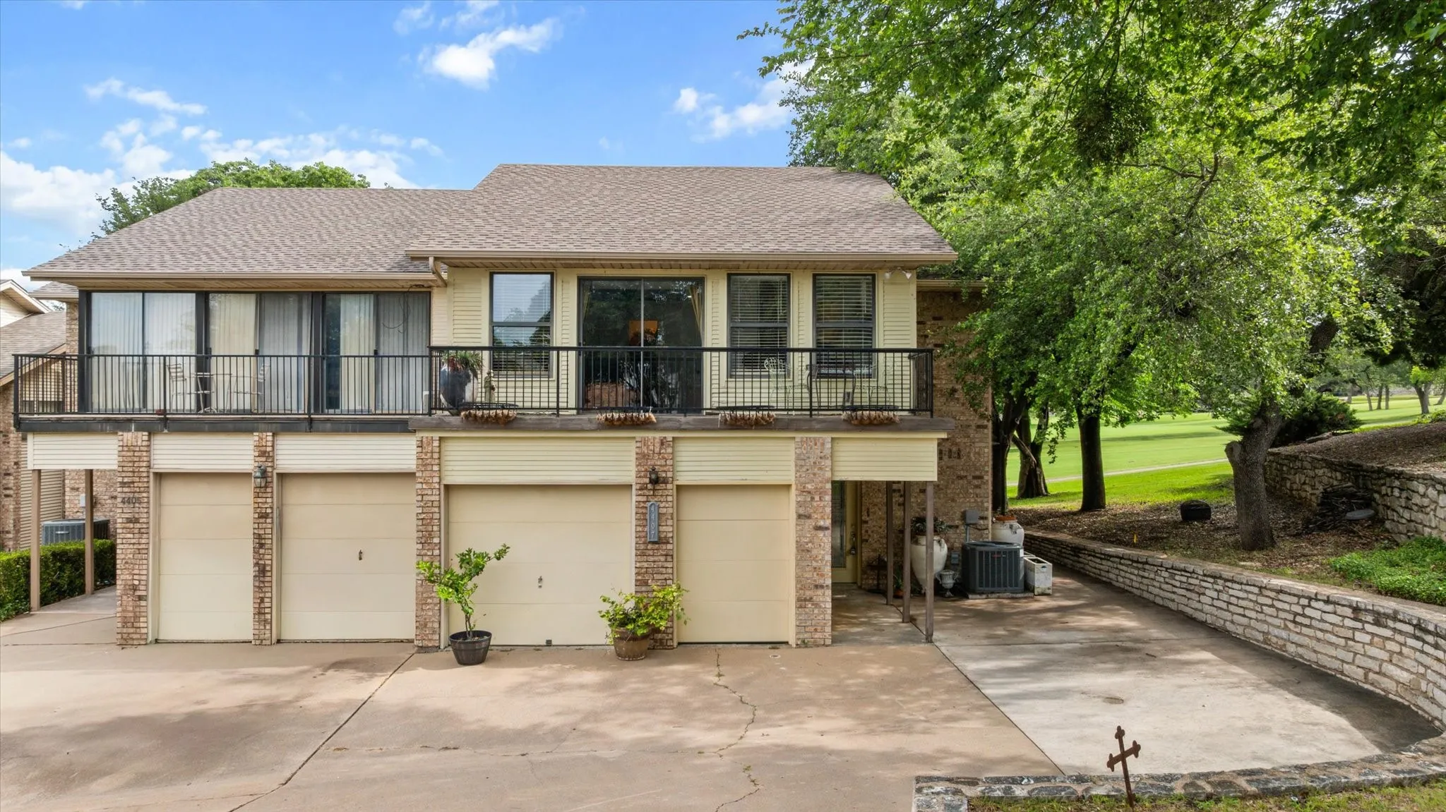 Multi-level property featuring a neutral exterior, and an upper-level balcony with black railing