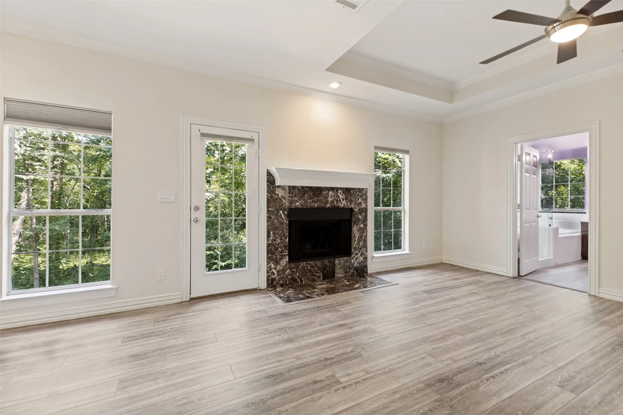 A third fireplace is this oversized primary bedroom with spectacular views of the nature filled yard!