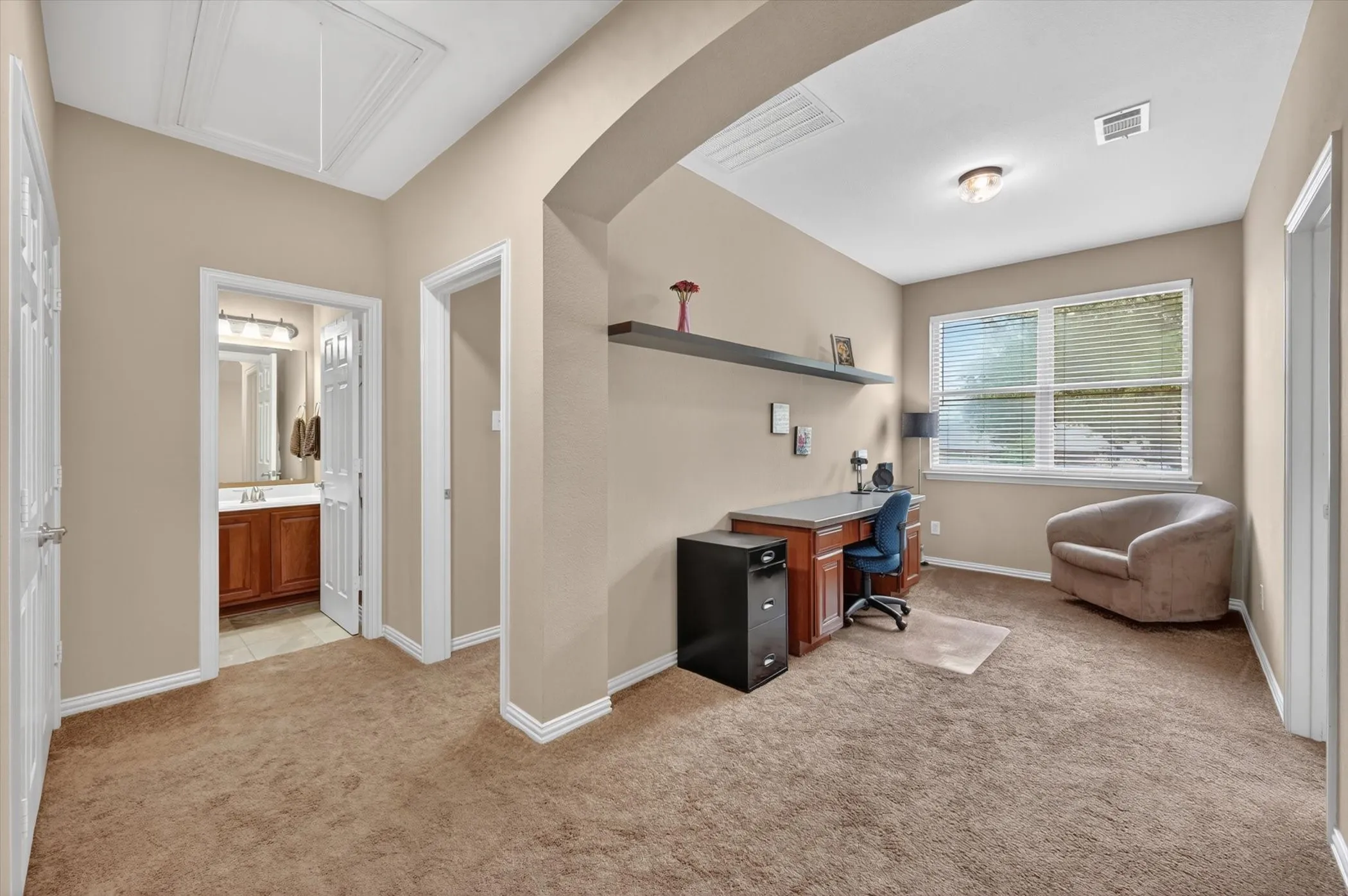 Carpeted room with neutral wall paint and white trim, featuring a window with horizontal blinds