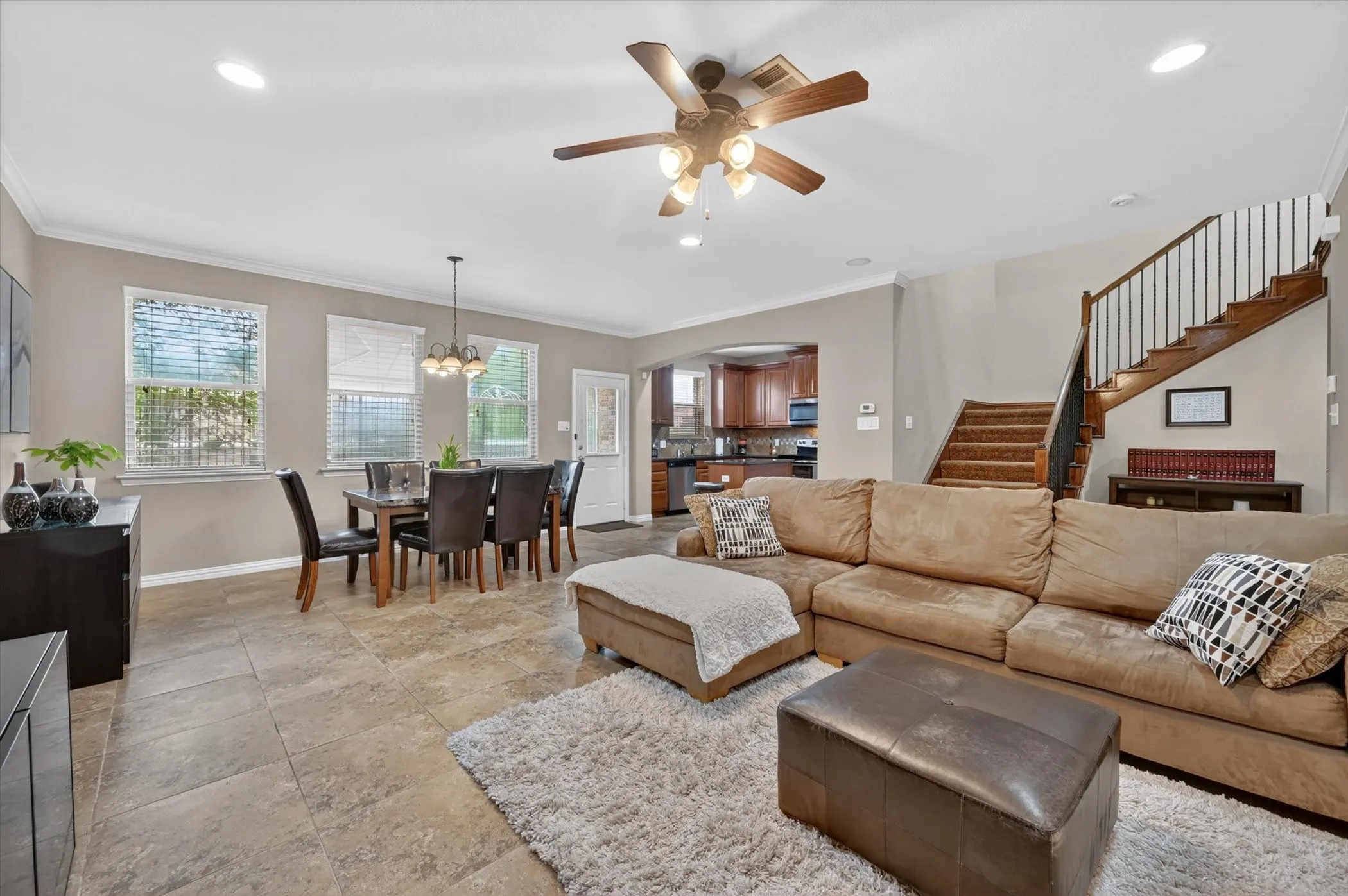 Open-concept living area with tile flooring and crown molding