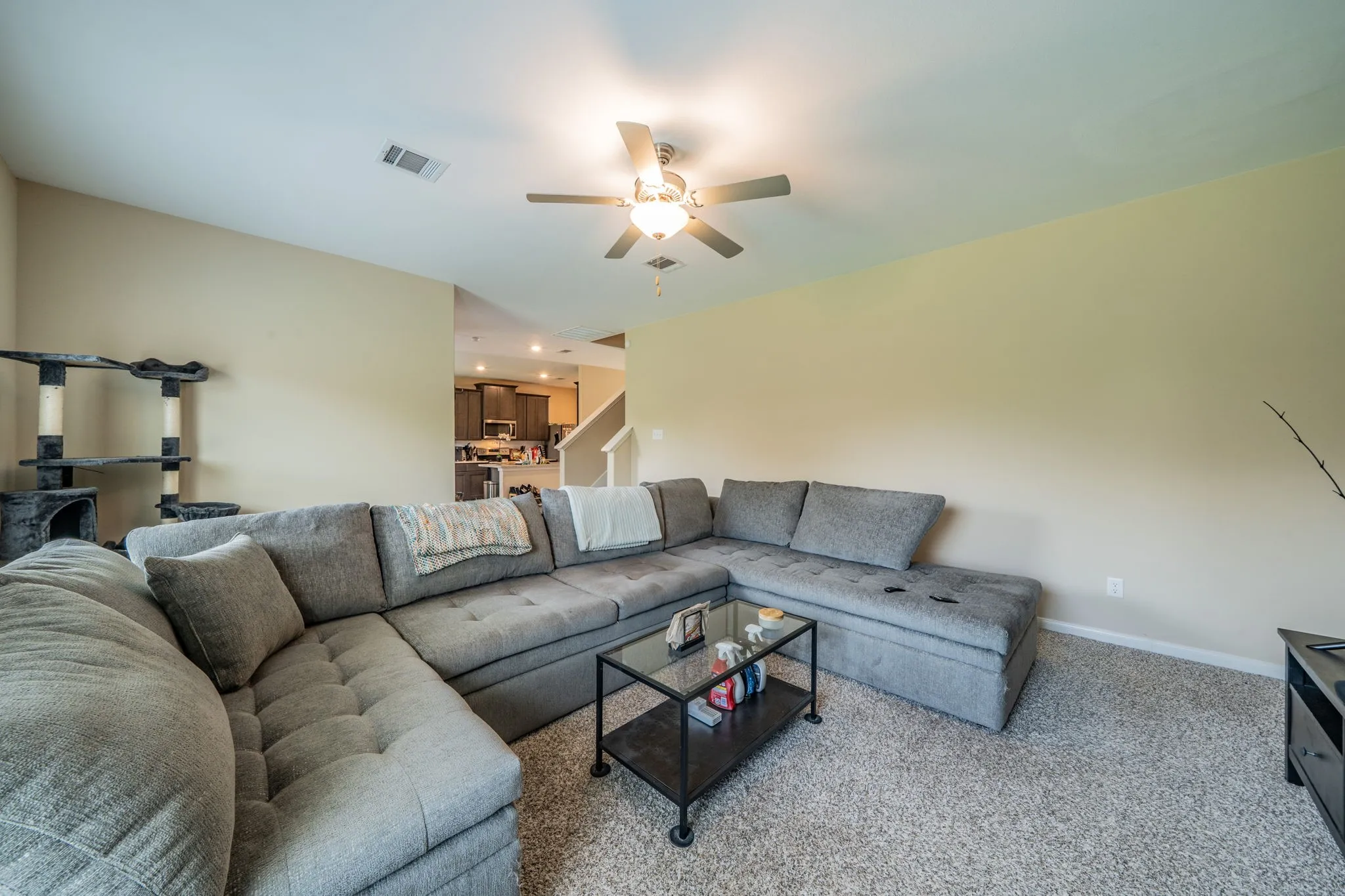 Spacious living area featuring neutral wall tones and textured carpeting