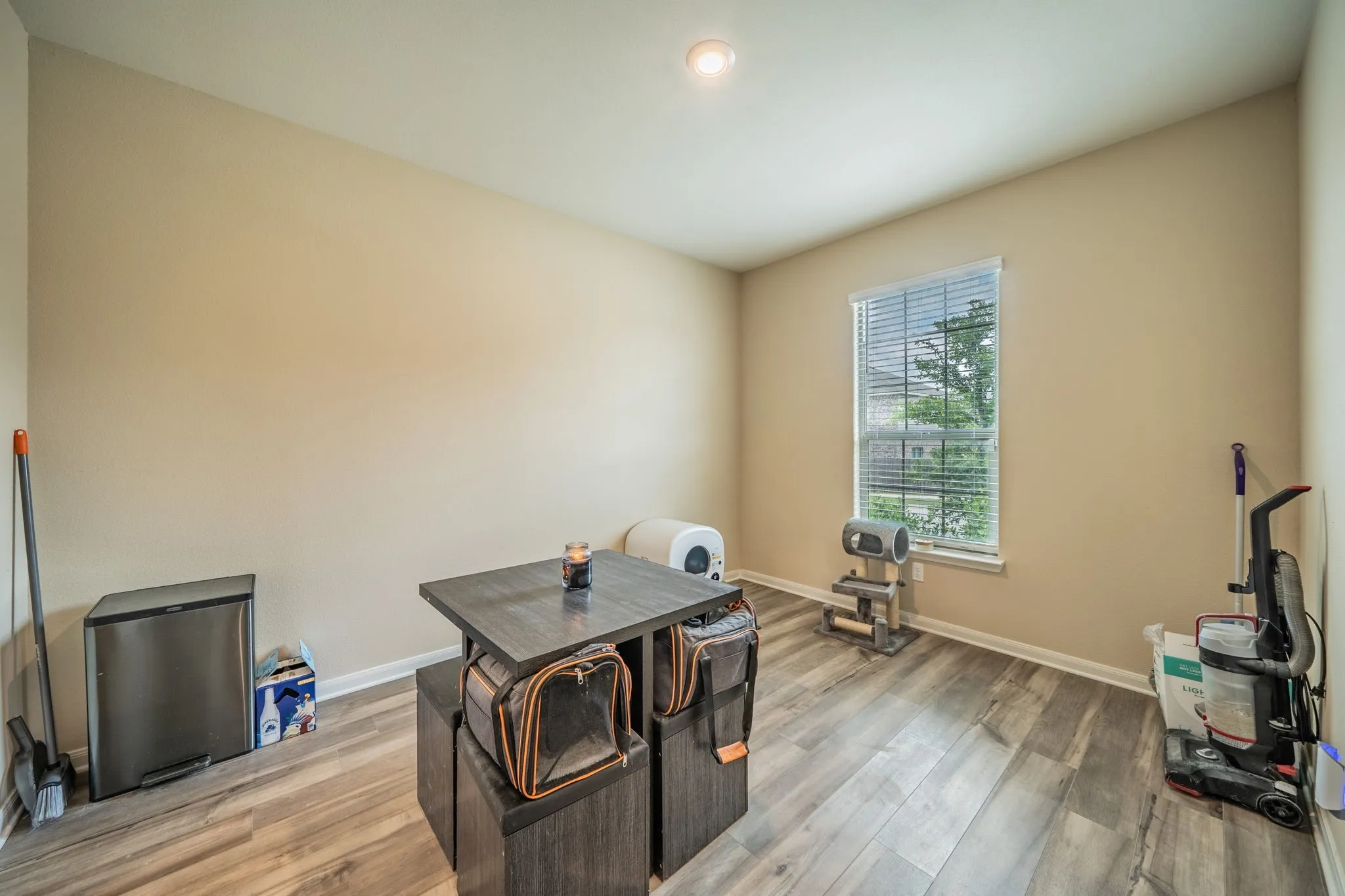 Room featuring wood-finish flooring, a single window with blinds, and recessed lighting