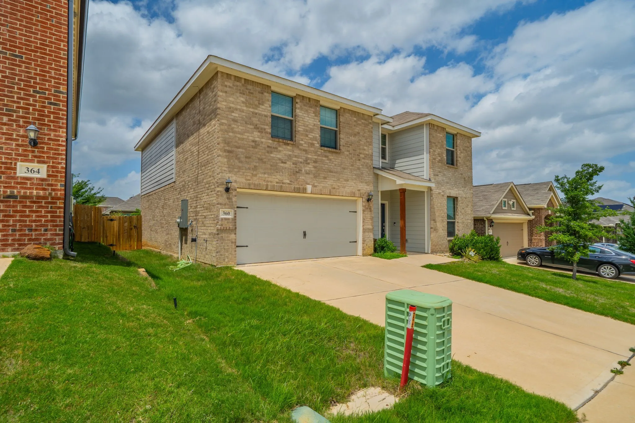 Two-story residential exterior featuring brick and siding finishes