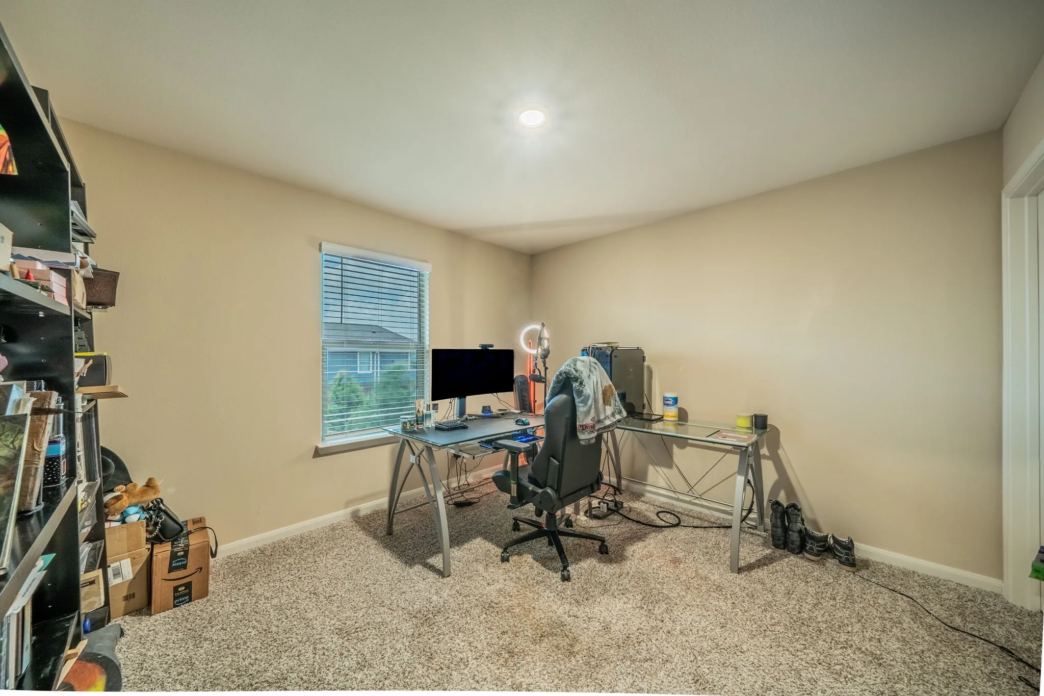 Carpeted room featuring a single window with blinds, a built-in overhead light, and neutral-toned walls