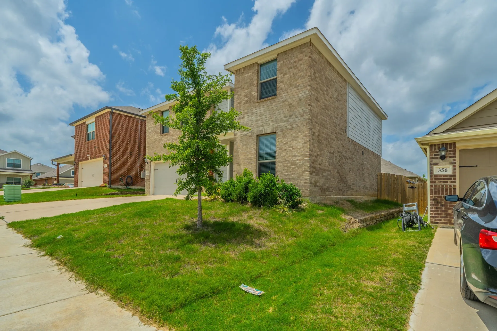Brick and siding exterior featuring multiple windows and a single garage door