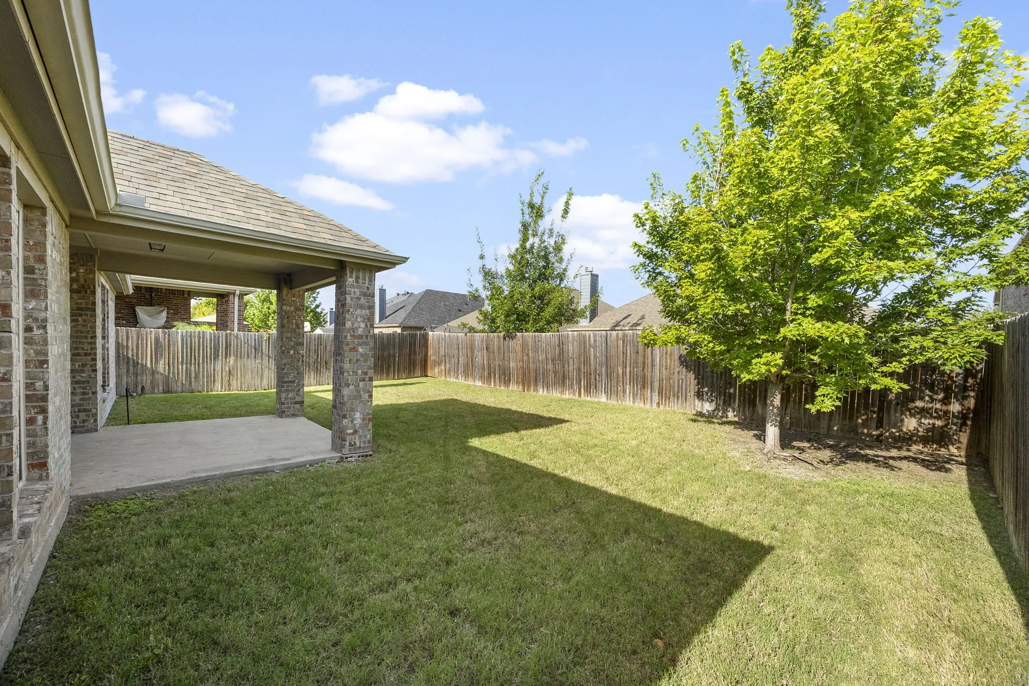 Side view of the covered patio and spacious yard.