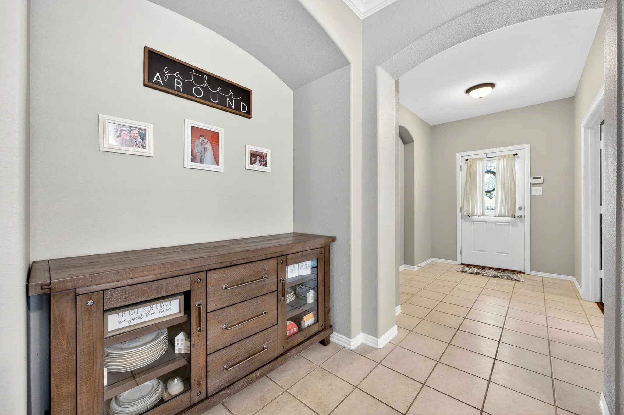 Inviting entryway featuring tile flooring, neutral wall tones, and an arched doorway