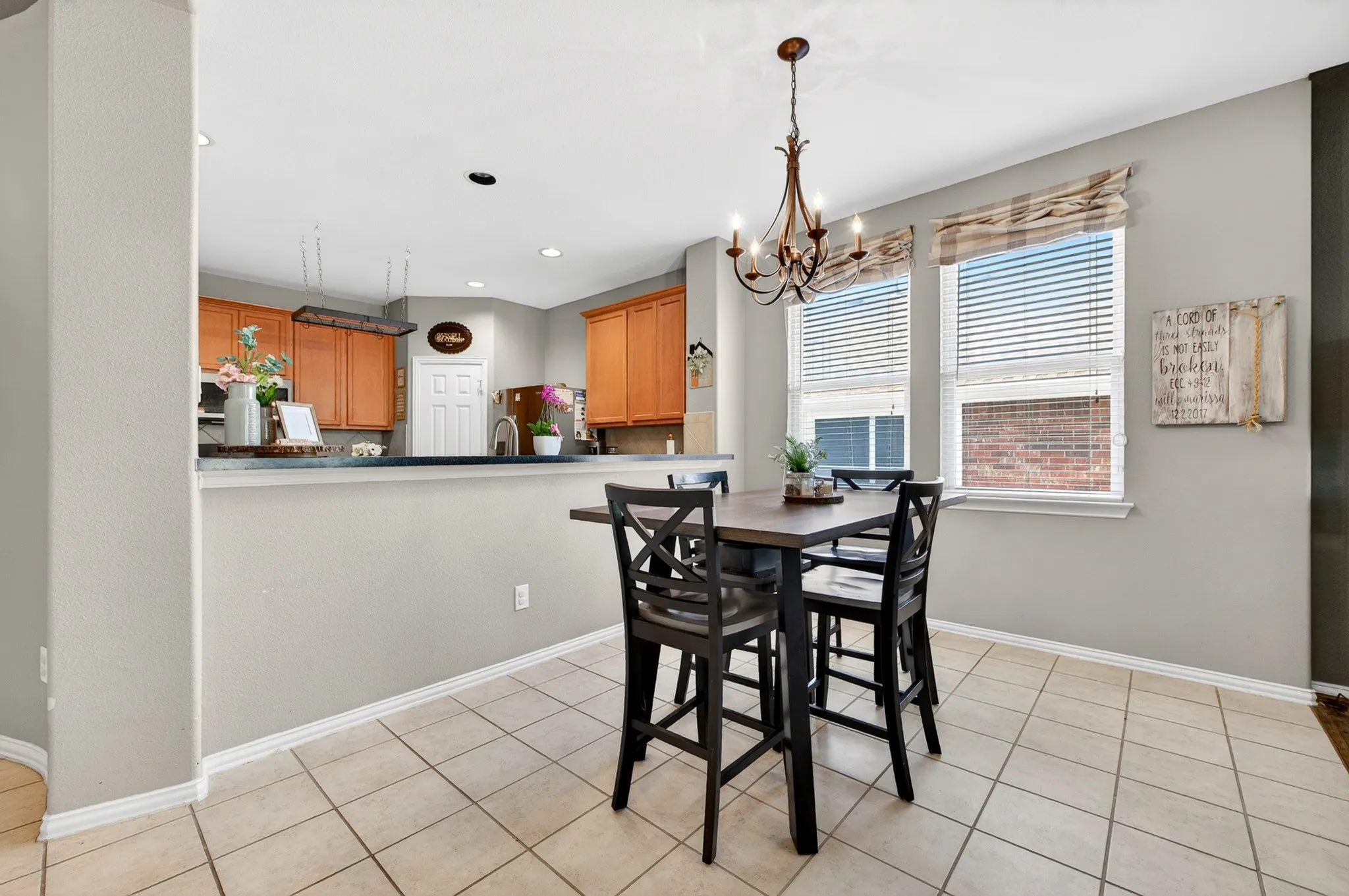 Kitchen and dining area featuring tile flooring, a breakfast bar, recessed lighting, and a decorative chandelier