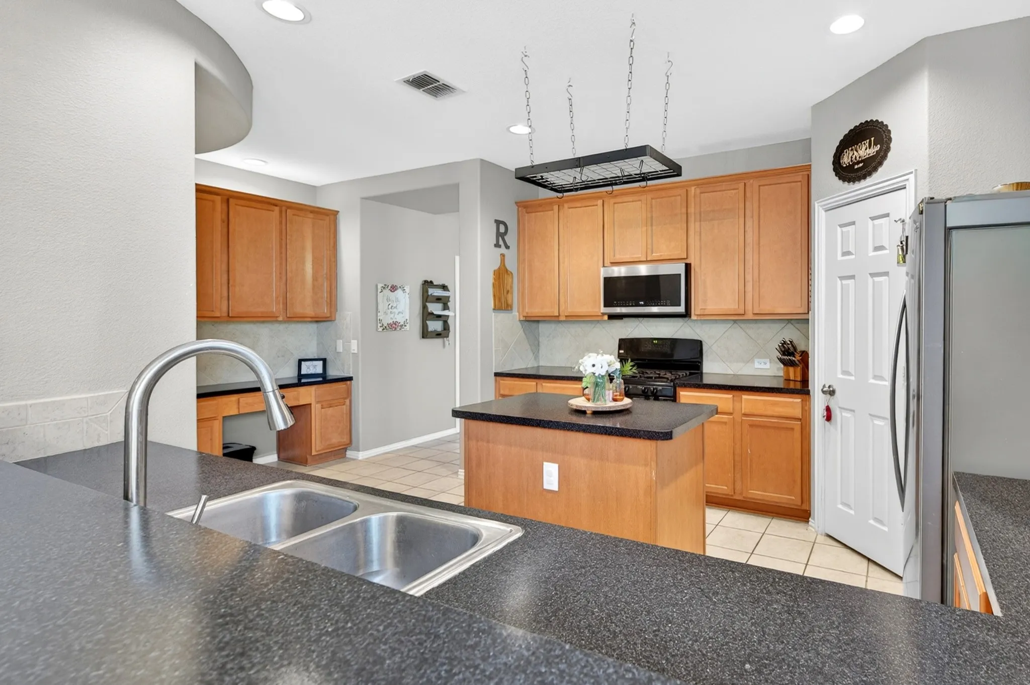 Kitchen featuring wood-finish cabinetry, dark countertops, and a central island