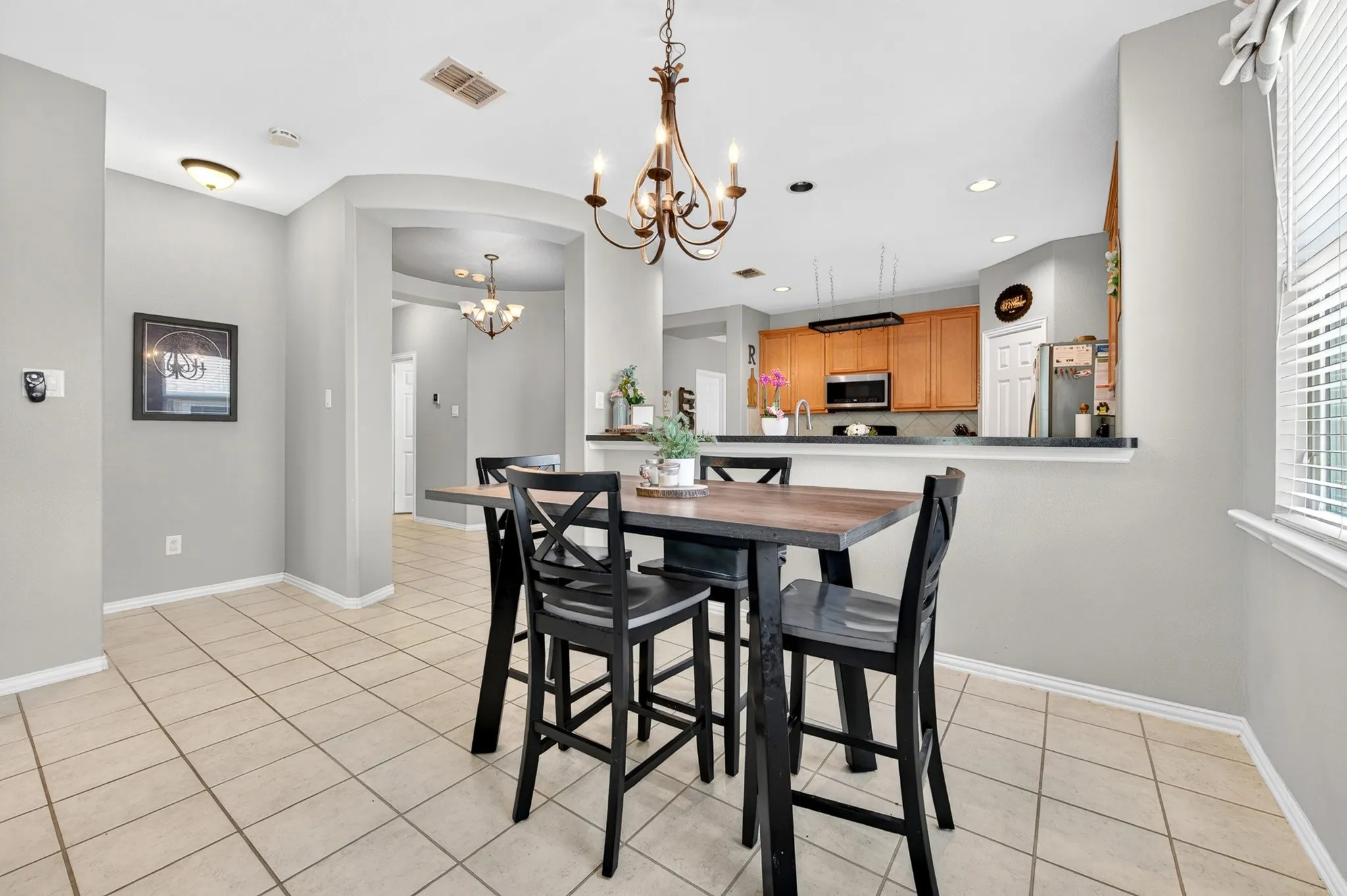 Dining area with tile flooring and an overhead chandelier