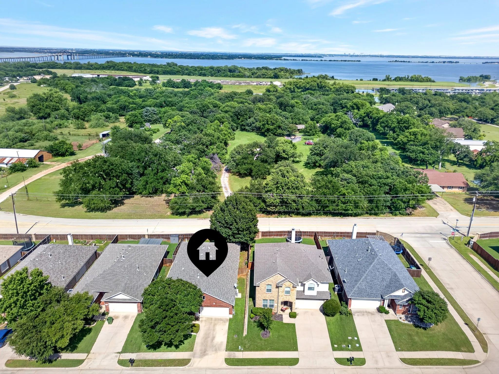 Overhead perspective of a residential street featuring varied home exteriors, shingled roofs, and private driveways