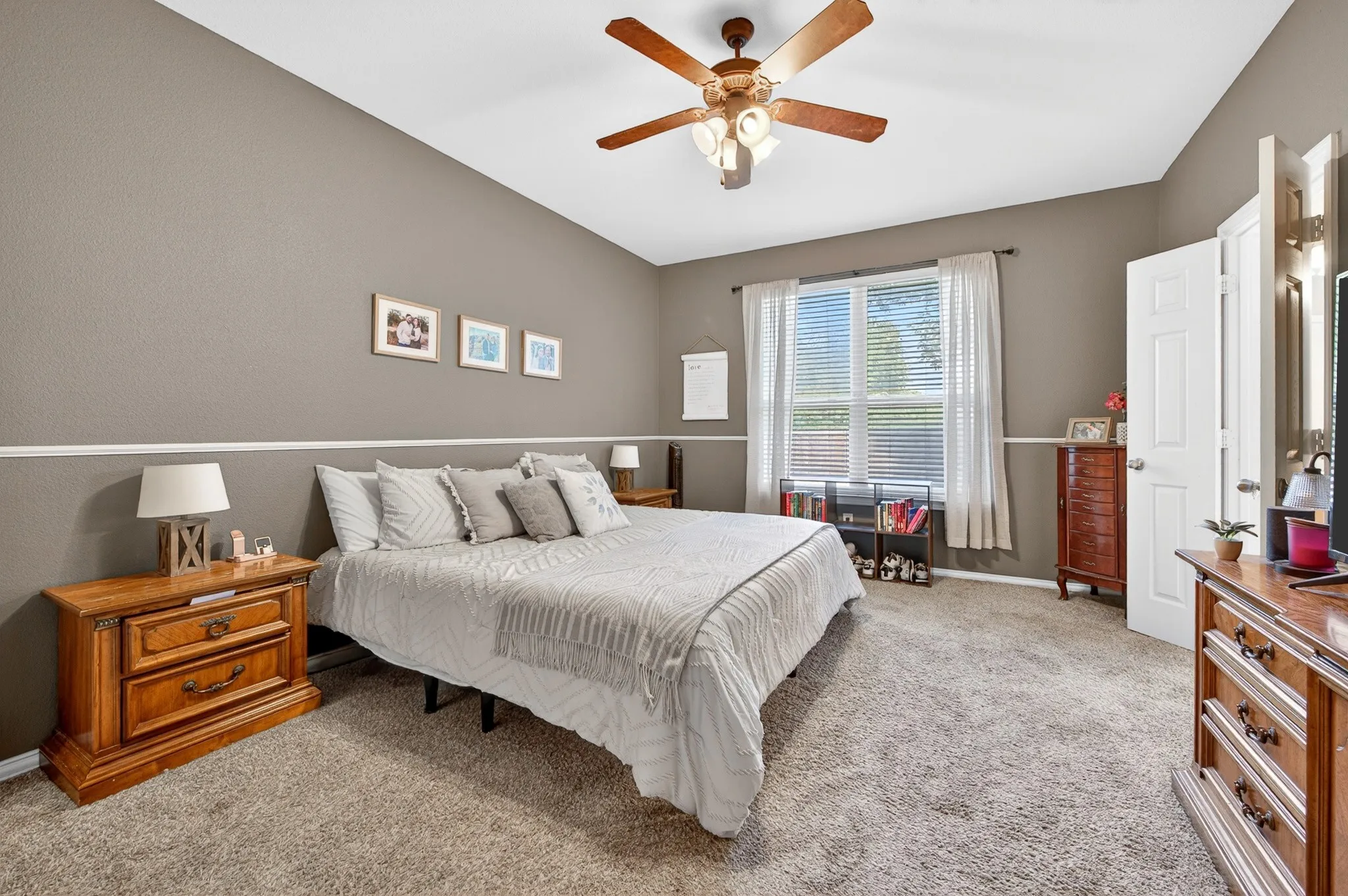 Carpeted room with vaulted ceilings and a ceiling fan