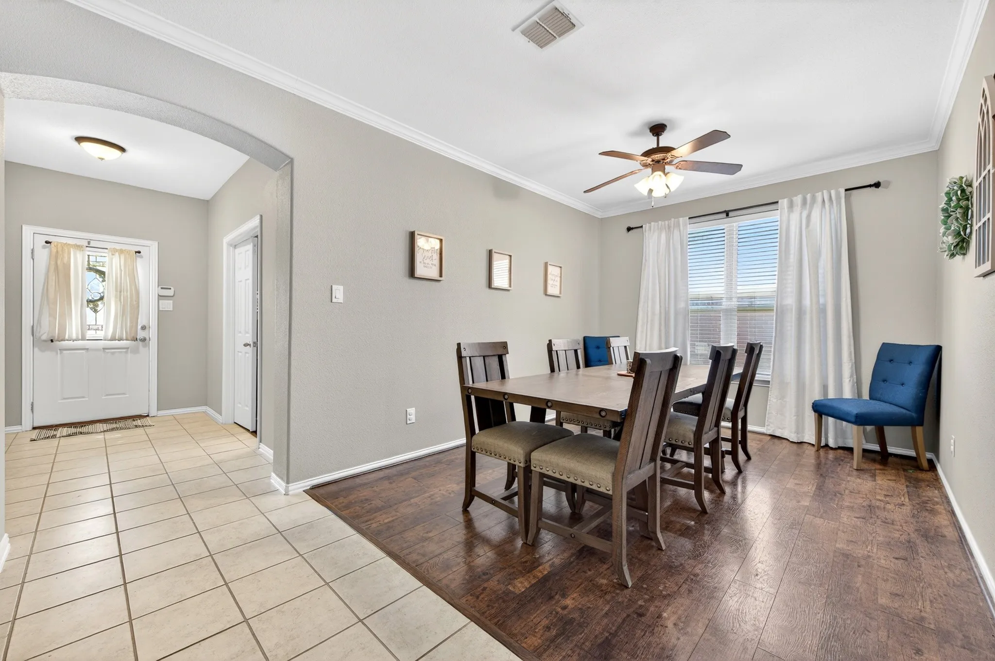 Dining area with wood-finish flooring, a ceiling fan, and a large window