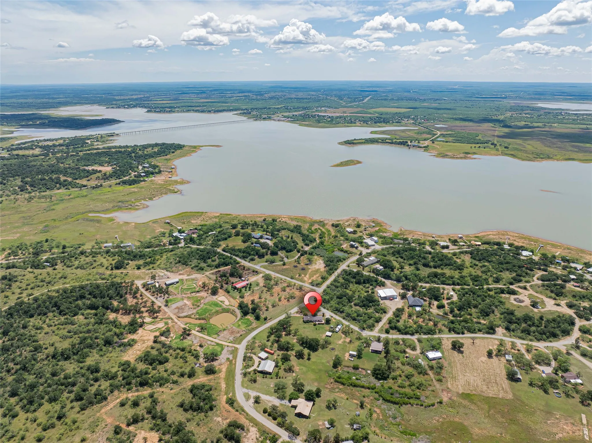 Aerial perspective showcasing the property's location near a large body of water, surrounded by abundant natural vegetation