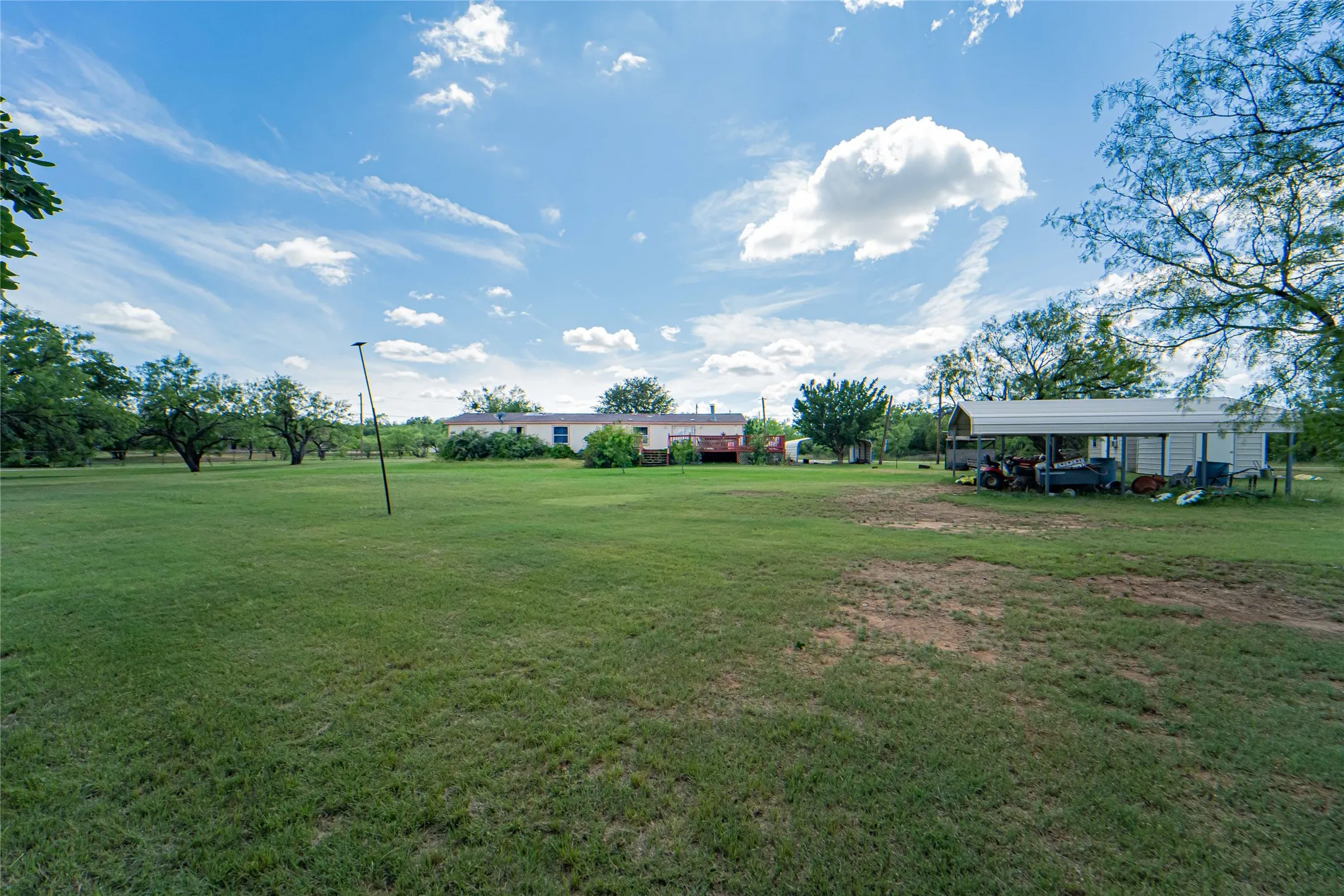 Expansive grassy yard with mature trees