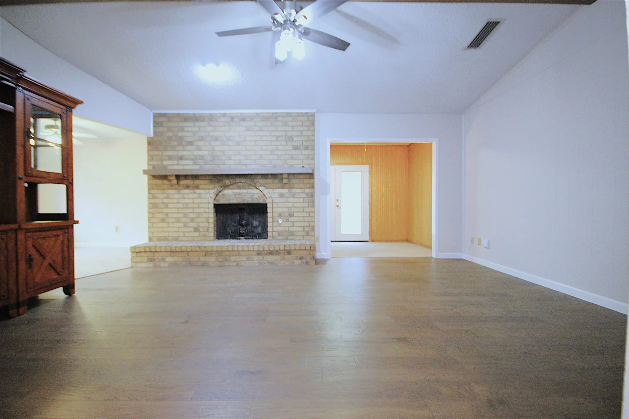 Ceiling to floor brick fireplace and hearth at the center of this home.