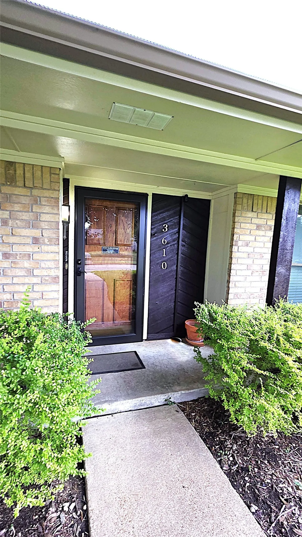 Front entry with storm door and sturdy wood door.