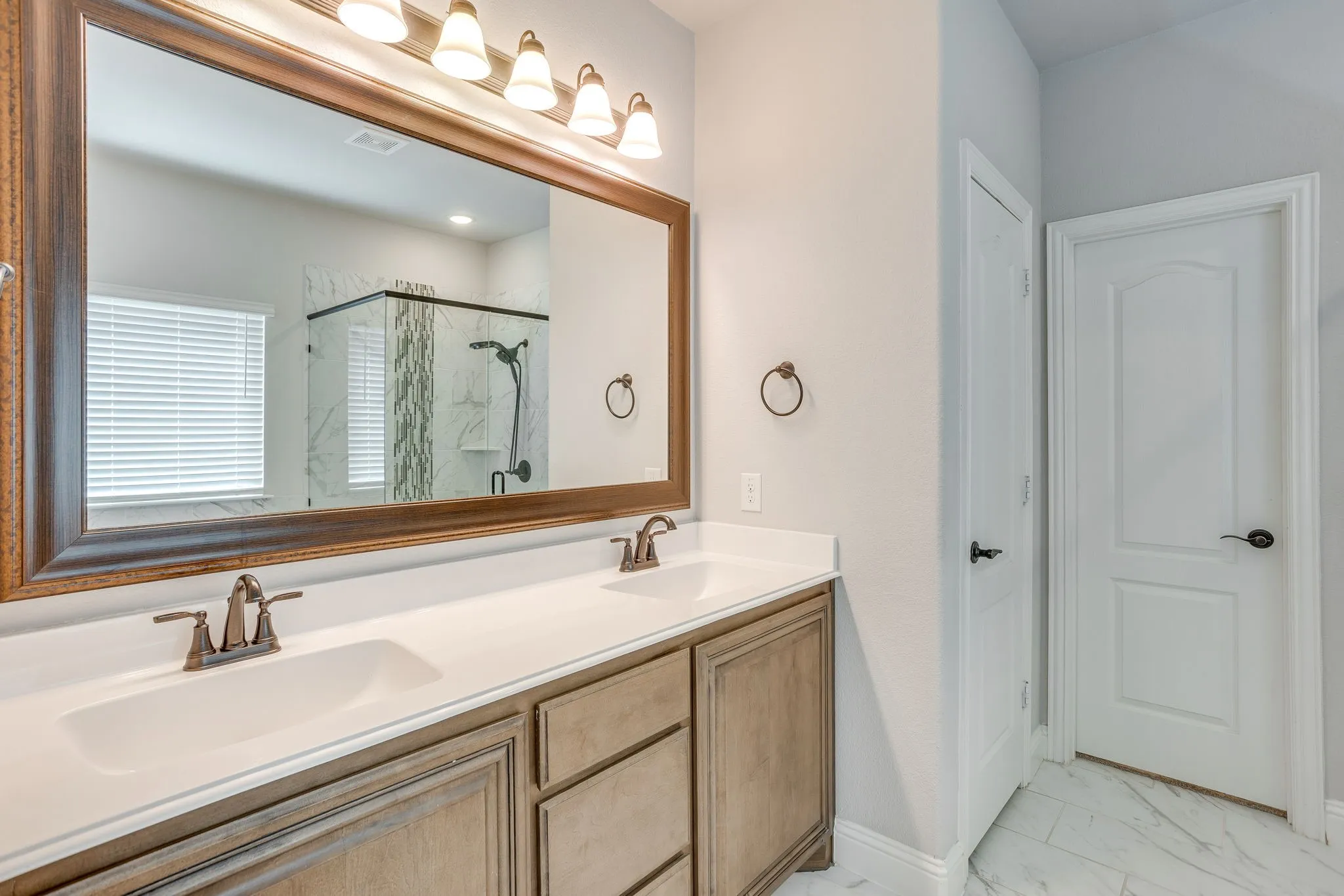 Double vanity with a white countertop and rectangular undermount sinks