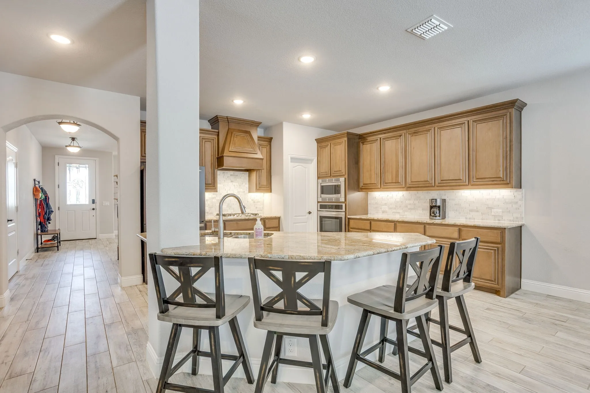 Kitchen island featuring a granite countertop, undermount sink, and integrated breakfast bar