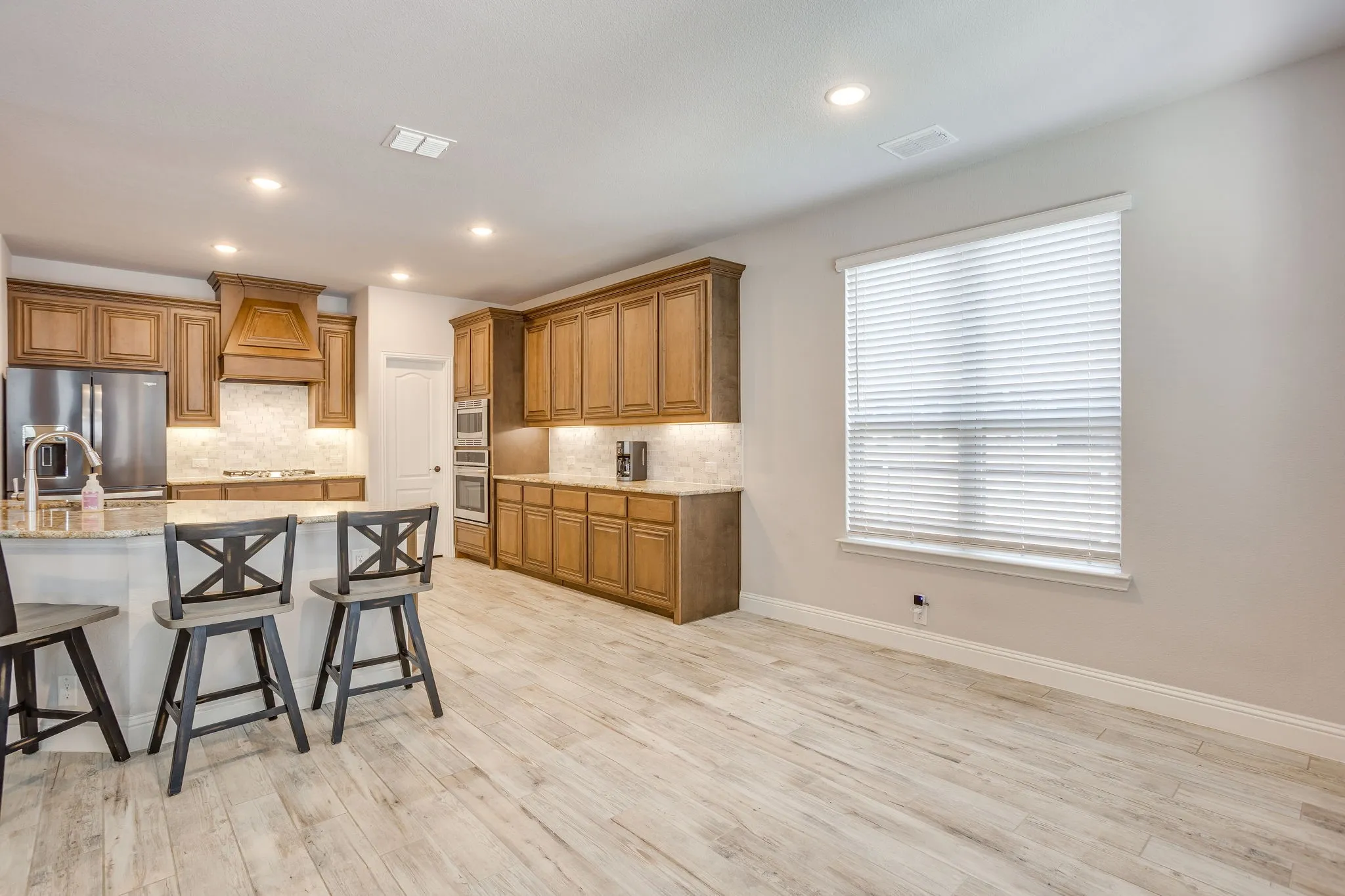 Kitchen featuring wood-finish cabinetry, stainless steel appliances, and a central island with countertop seating