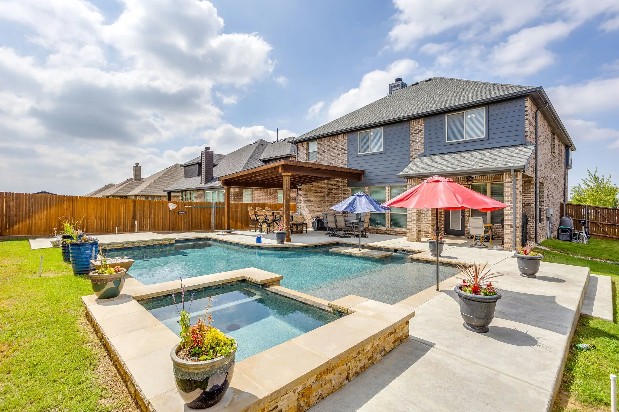 Expansive backyard featuring a large swimming pool with an integrated spa