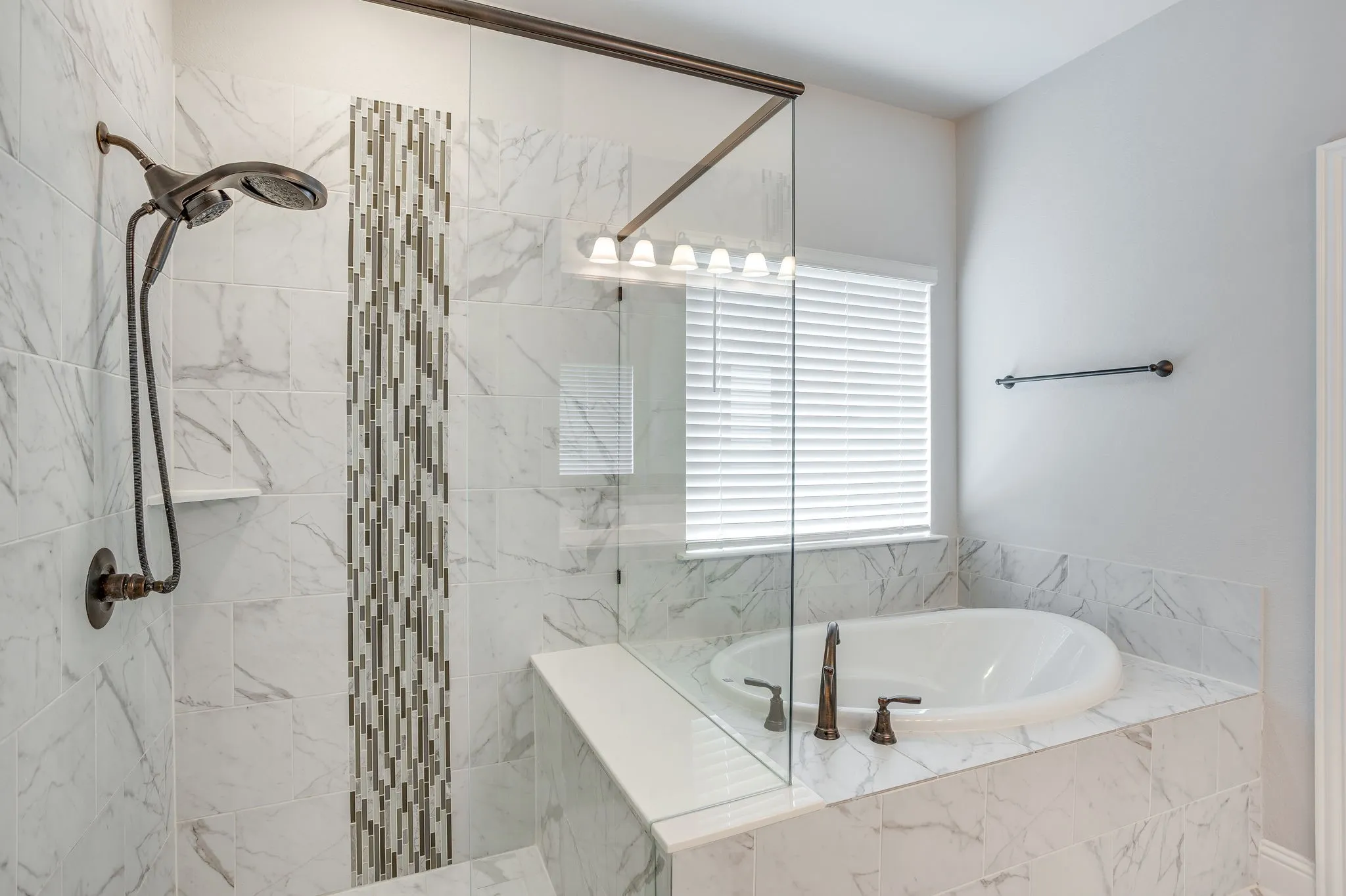 Bathroom featuring a built-in soaking tub, a walk-in shower with a glass enclosure, and white marble-look tile