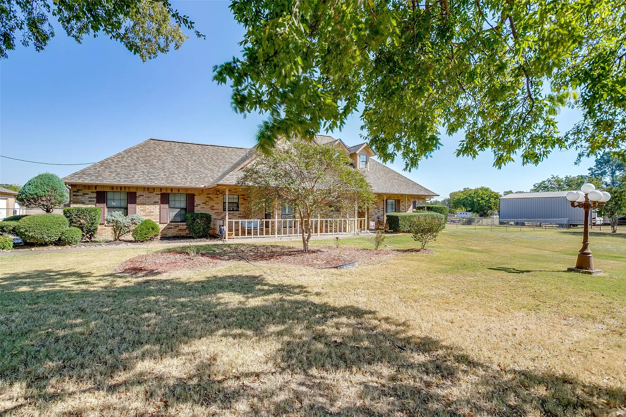 Front view of large yard mature trees and front of home.