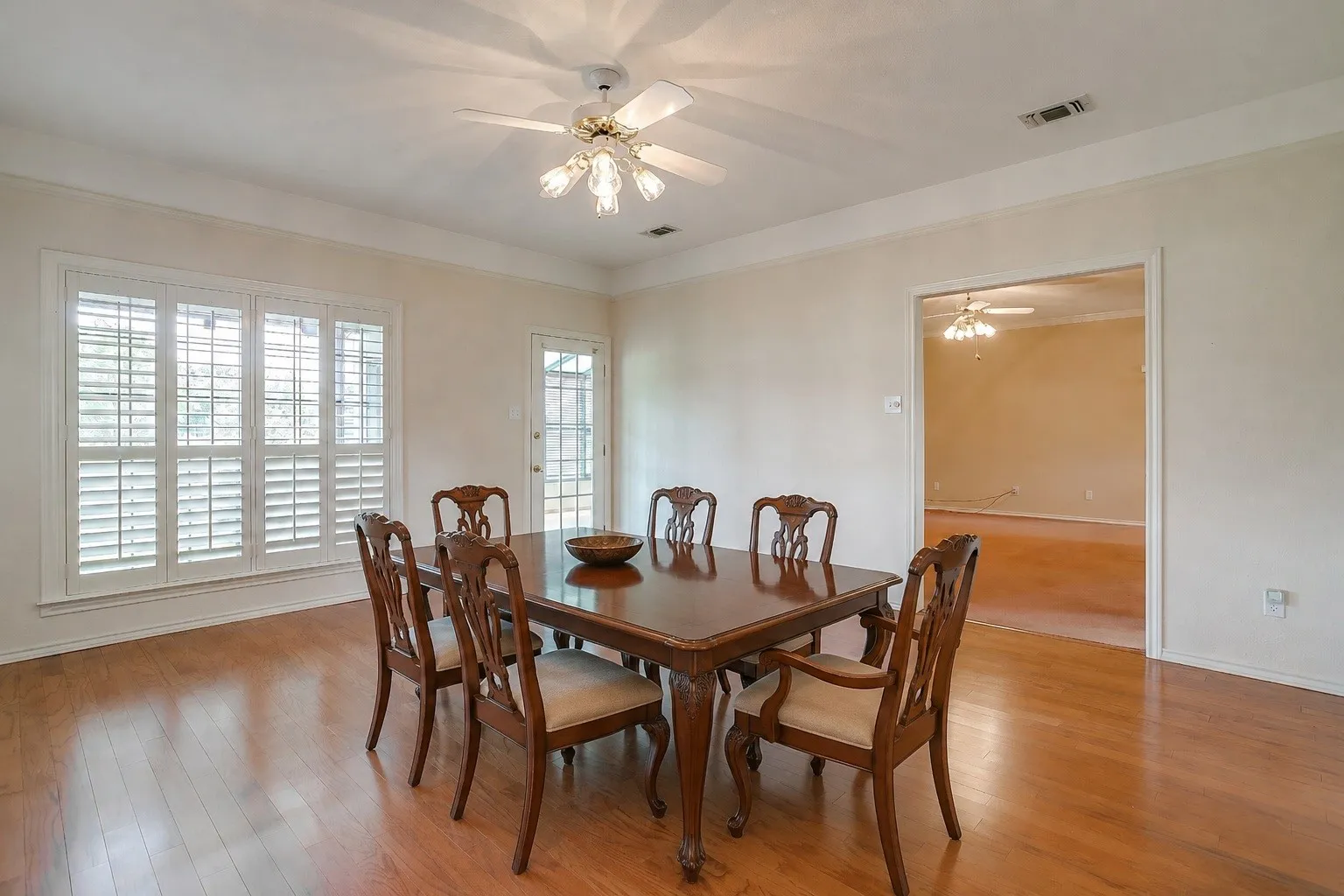 Dining area featuring wood-finish flooring and crown molding. Virtually Staged photo.
