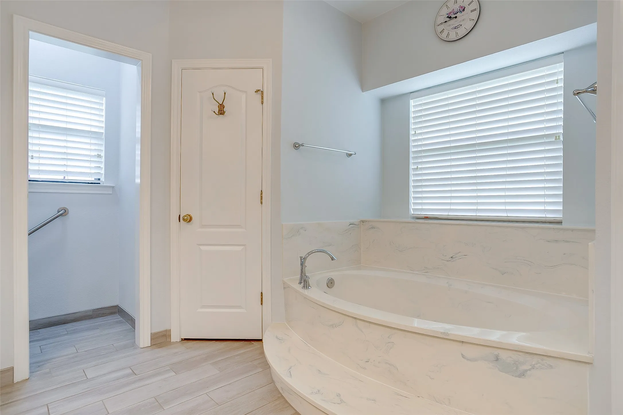 Soaking tub with a polished stone surround and deck-mounted fixtures