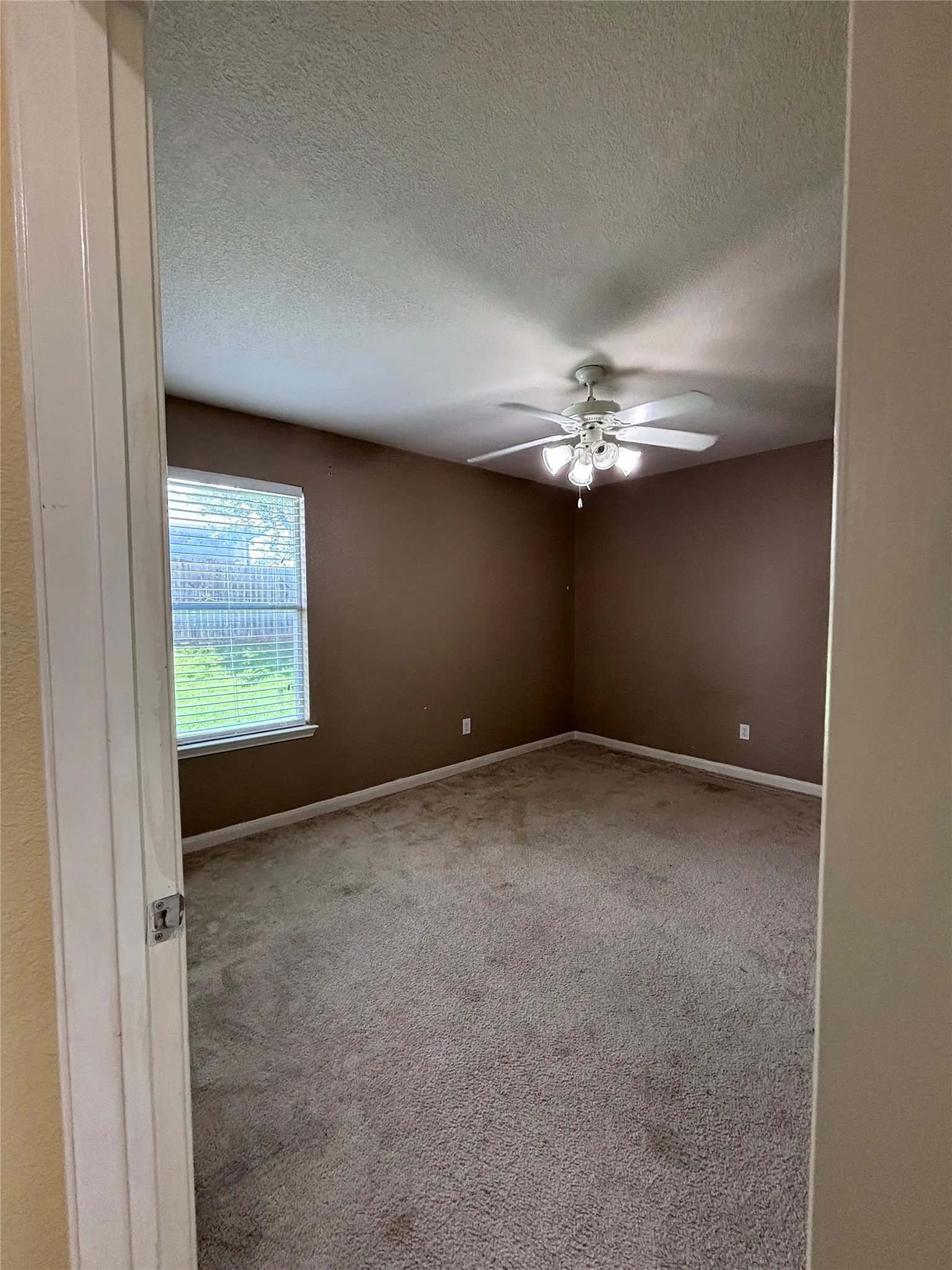 Bedroom featuring neutral-toned carpet flooring and warm brown wall paint