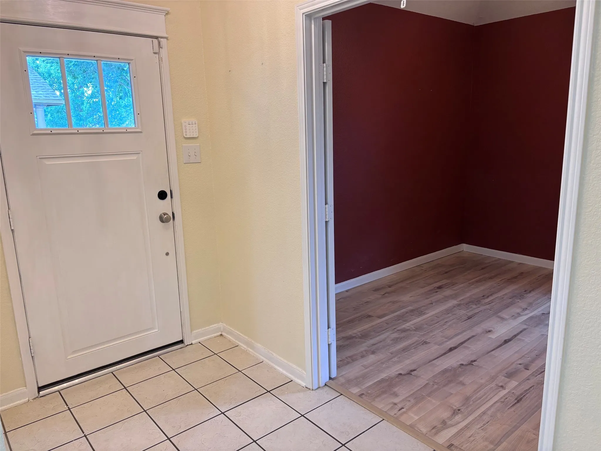 Entryway with white panel door featuring a multi-pane window and a tiled floor