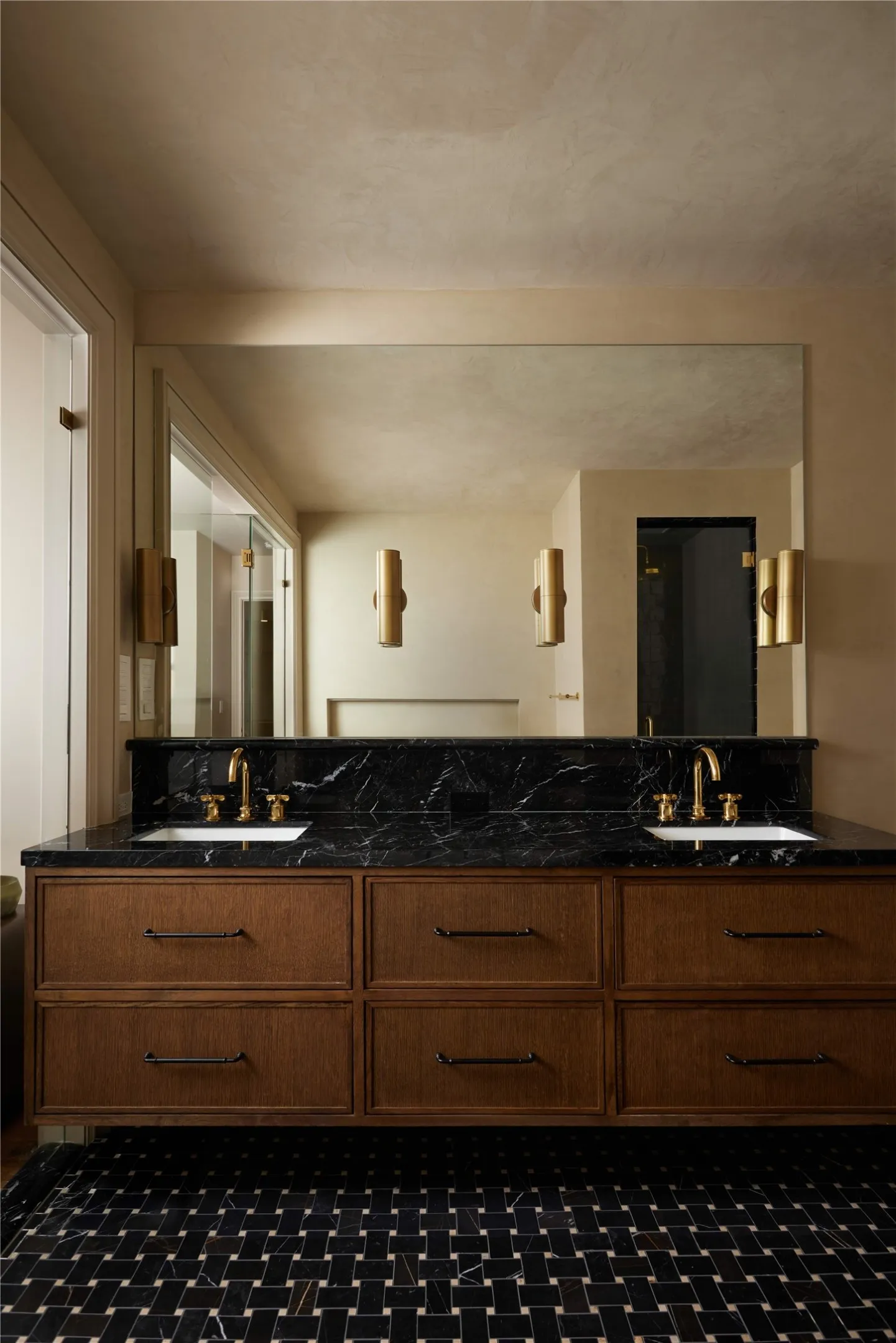 Dual vanity featuring a black stone countertop with a matching backsplash and integrated sinks